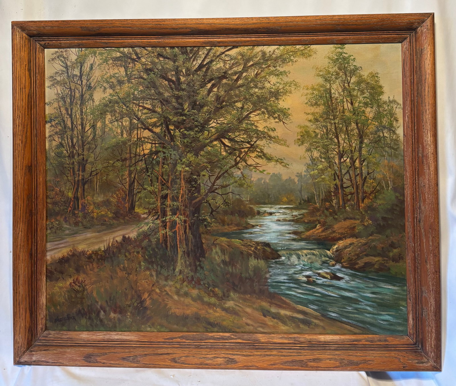 Michael Hasselbar (American, 1900–1949) Woodland Stream Oil on Canvas: It is Michael Hasselbar (American, 1900–1949) oil on canvas depicting a tranquil woodland landscape with a flowing stream, towering trees, and a country road beneath soft natural light. Executed wit
