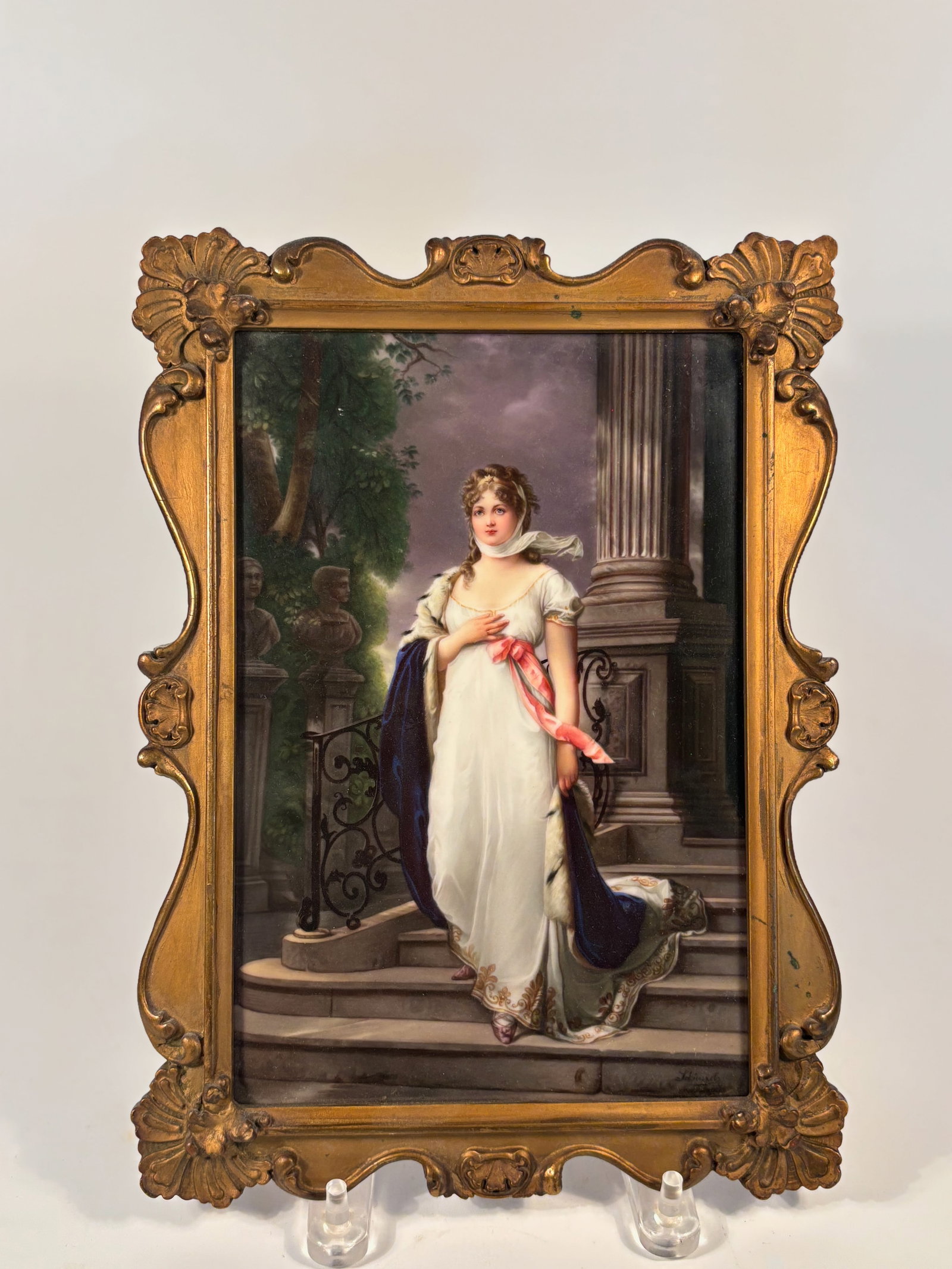 A KPM Porcelain Plaque of Queen Louise: Late 19th to early 20th centurySigned: SchinzelImpressed mark: 308 ; Finely painted rectangular porcelain plaque, depicting an elegant scene of a crowned noblewoman in regal attire descending a marble