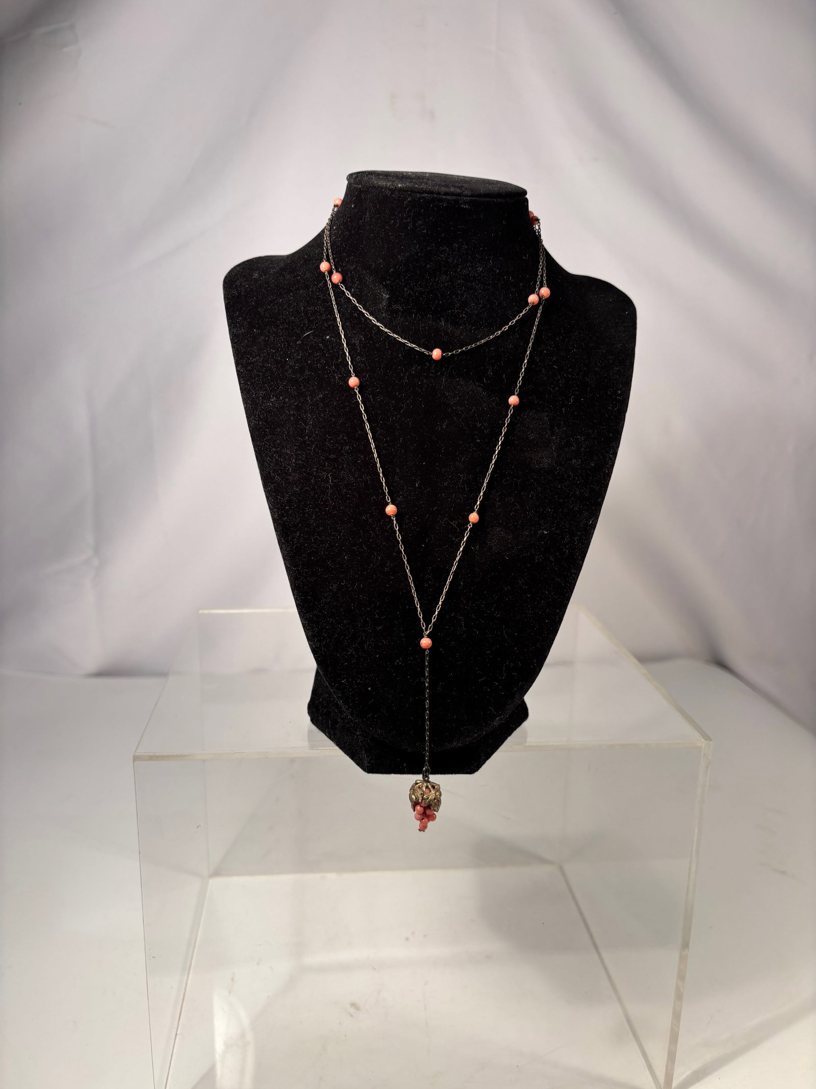 A Long Natural Salmon Coral like Bead Necklace with Coral Cluster Pendant on Silver Chain: This elegant necklace is composed of small natural salmon-pink coral beads delicately spaced along a fine silver chain, terminating in a charming coral cluster pendant formed from tiny natural coral b