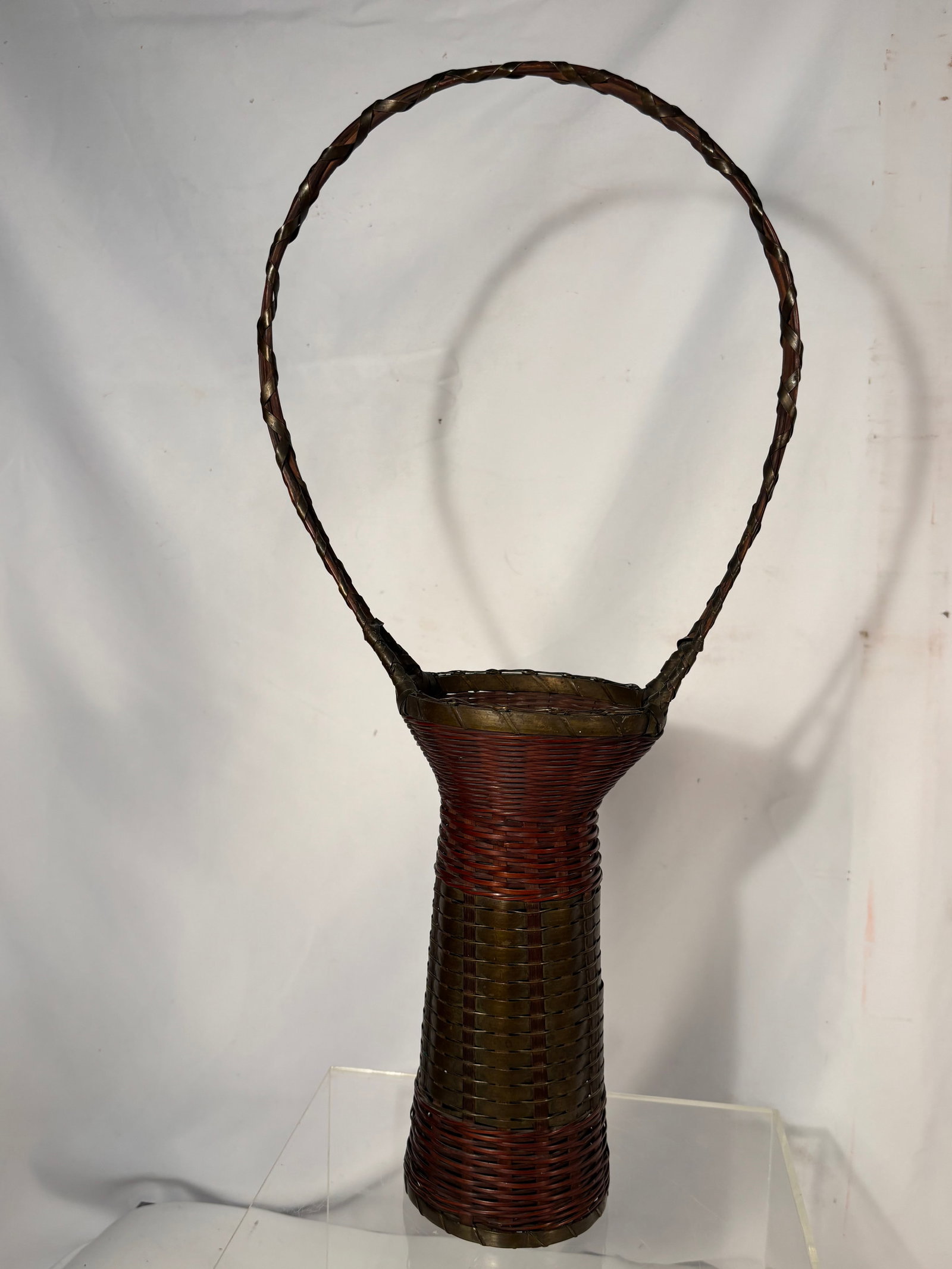 1920s Japanese Ikebana Hanakago Bamboo and Copper Basket with Copper Insert: A finely crafted Japanese ikebana flower-arranging basket, dating to the 1920s, featuring a tall cylindrical form handwoven from reddish-brown bamboo with contrasting woven copper elements. The basket