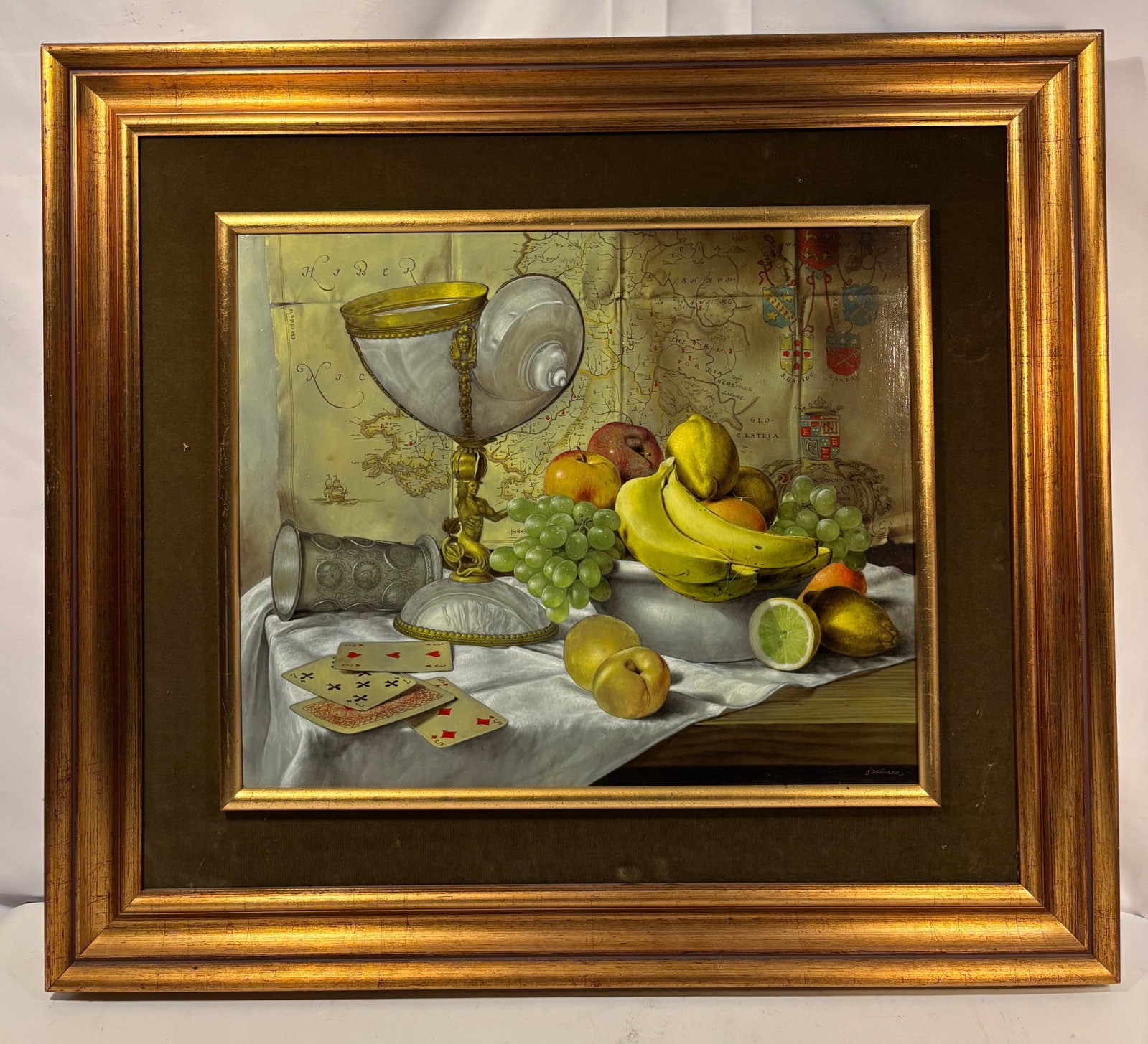 Jerzy Müller (Polish, b. 1954), Still Life with Nautilus Cup, Fruit and Antique Map, Oil on Canvas: Jerzy Müller (Polish, b. 1954). A finely executed oil on canvas depicting an elaborate still life with a mounted nautilus-shell cup, embossed silver vessel, grapes, bananas, apples, citrus fruit, and