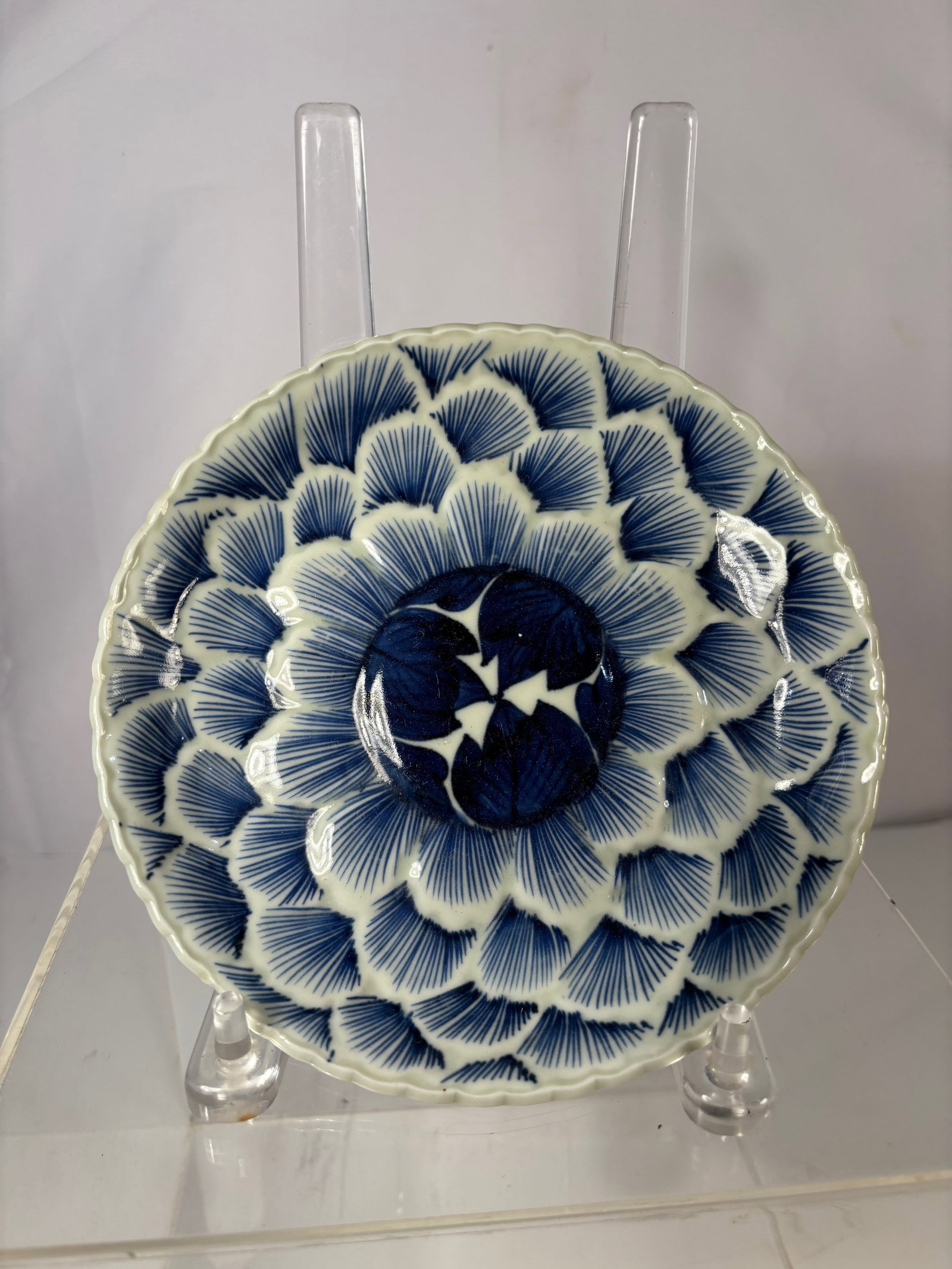 A Japanese Arita Blue-and-White Chrysanthemum-Petal Dish, Late Edo to Early Meiji Period (circa: Finely painted with radiating chrysanthemum petals in rich cobalt blue, centered with a bold flower medallion. The reverse with butterflies in flight, bearing an underglaze blue square mark.?Dimension