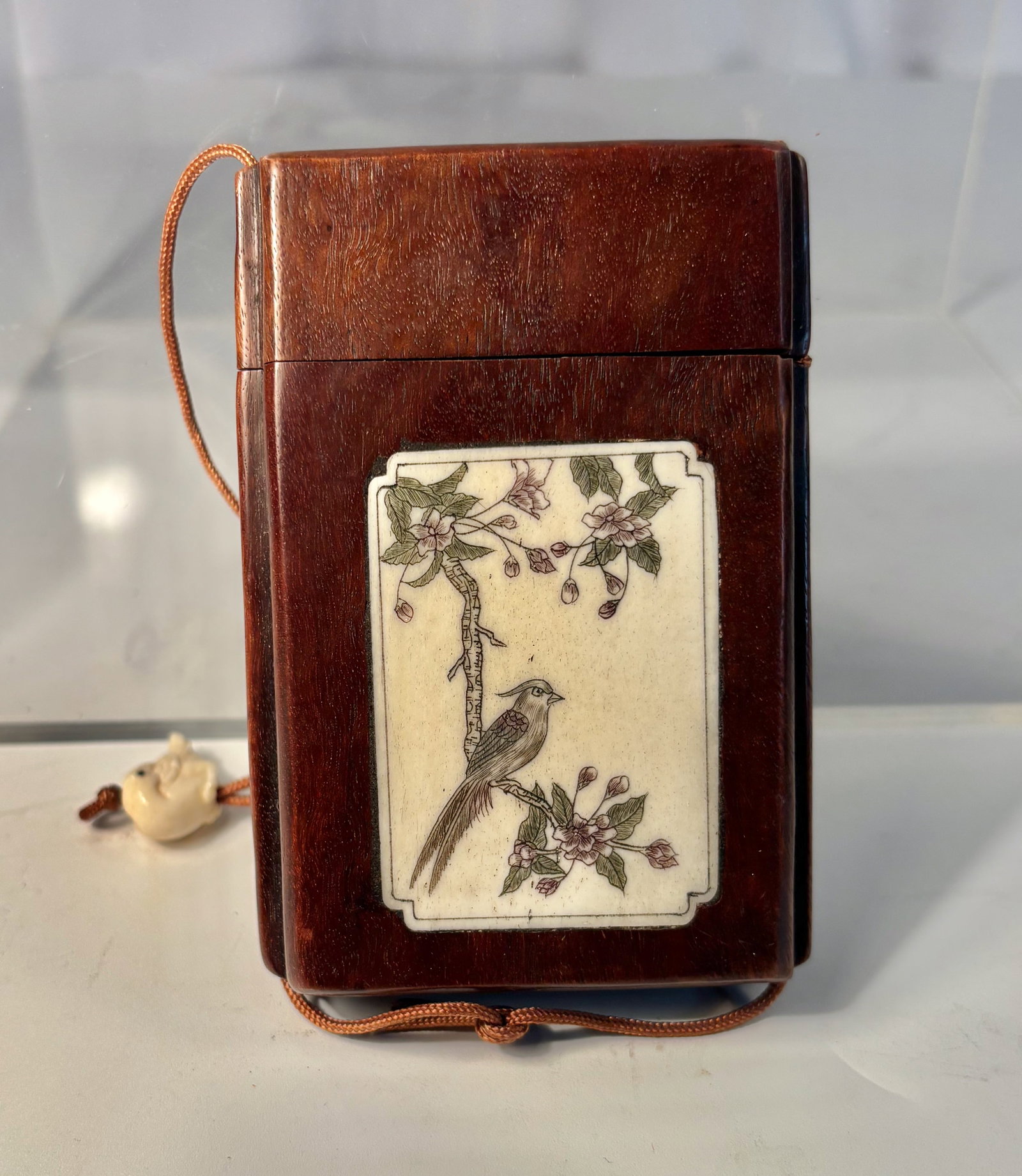 A Japanese Inro-Style Wood Case with Hand-Painted Bone Plaque: Meiji Period (1868-1912); A finely crafted Japanese inro-style wood case, dating to the Meiji period (circa 1868–1912). The exterior is fitted with a rectangular bone plaque, delicately painted with