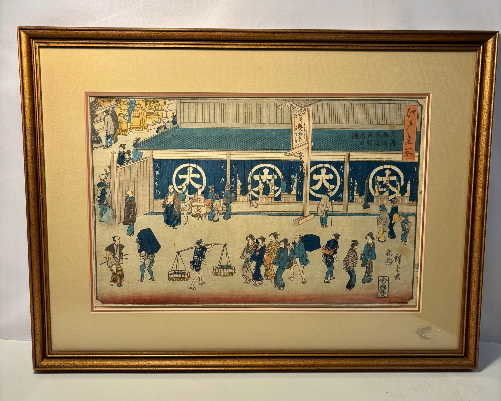 Utagawa Hiroshige, Edo Street Scene with Merchant Establishment, Japanese Woodblock Print: Japanese polychrome woodblock print by Utagawa Hiroshige (1797–1858), depicting a bustling Edo period street scene before a large merchant establishment. Numerous figures, including townspeople and 