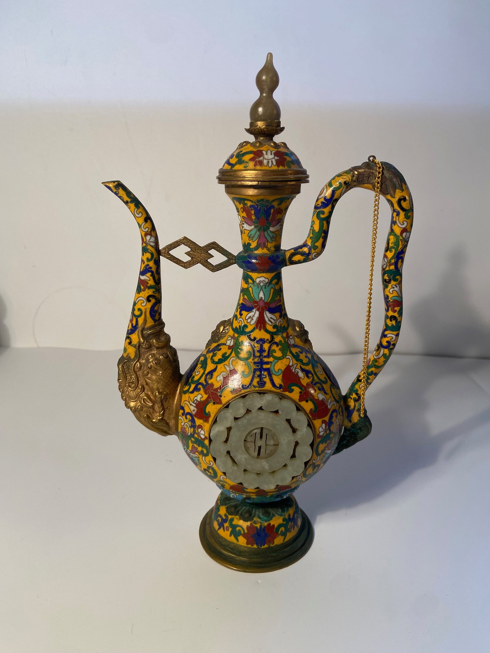 A Chinese yellow cloisonné teapot/ewer with jade inlaid: Late 19th century to Early 20th century,A Chinese yellow cloisonné teapot/ewer with jade inlaid, featuring colorful enamel and jade inserts on the body of the vessel suggest a higher level of craftsm