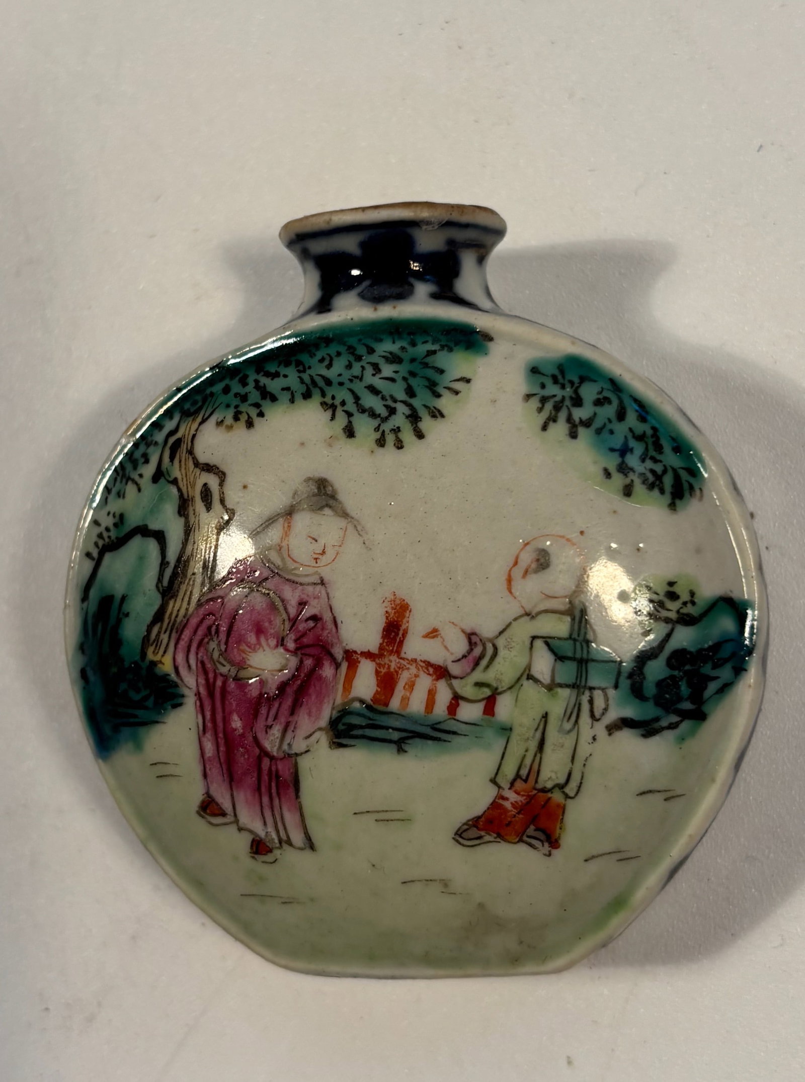 A Chinese Porcelain Snuff Bottle with "QIANLONG" mark: Qing Dynasty (1644-1912) ;Both sides feature figures in traditional dress, likely in a garden or courtyard settingDimensions?Height: 2.25 inches
