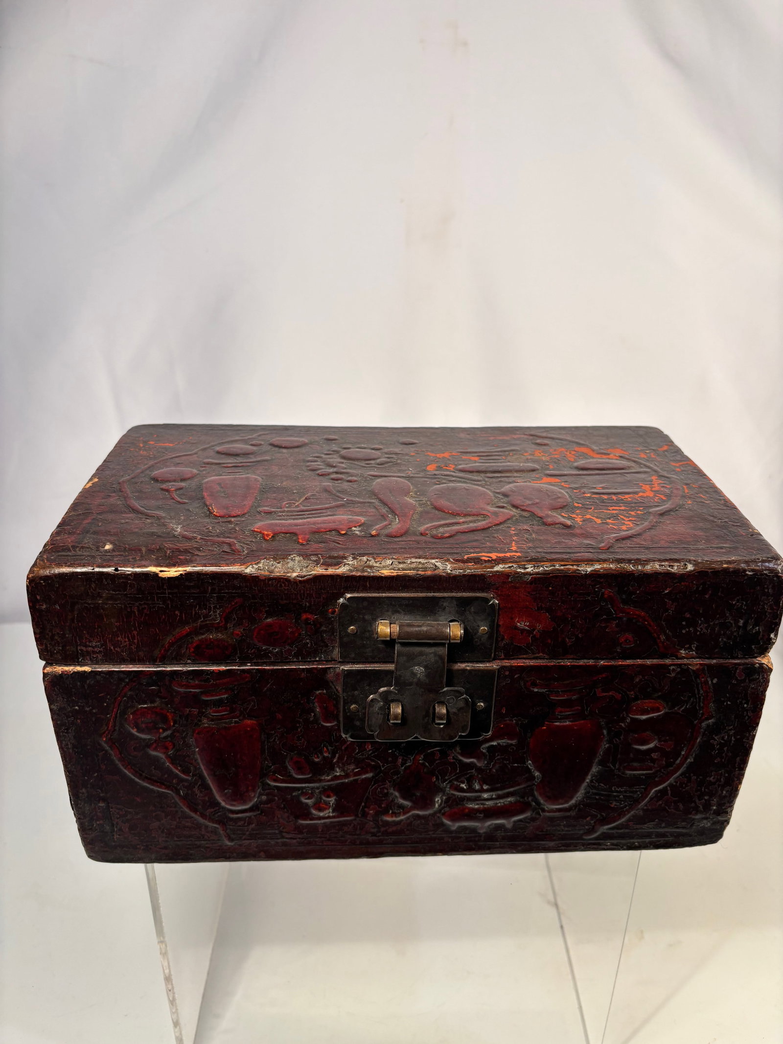 A Chinese Carved Laquer Box: Qing dynasty(1644-1912); Rectangular wood box with hinged lid, the exterior deeply carved with auspicious motifs in red cinnabar lacquer, fitted with brass hardware. Interior lacquered black with age 