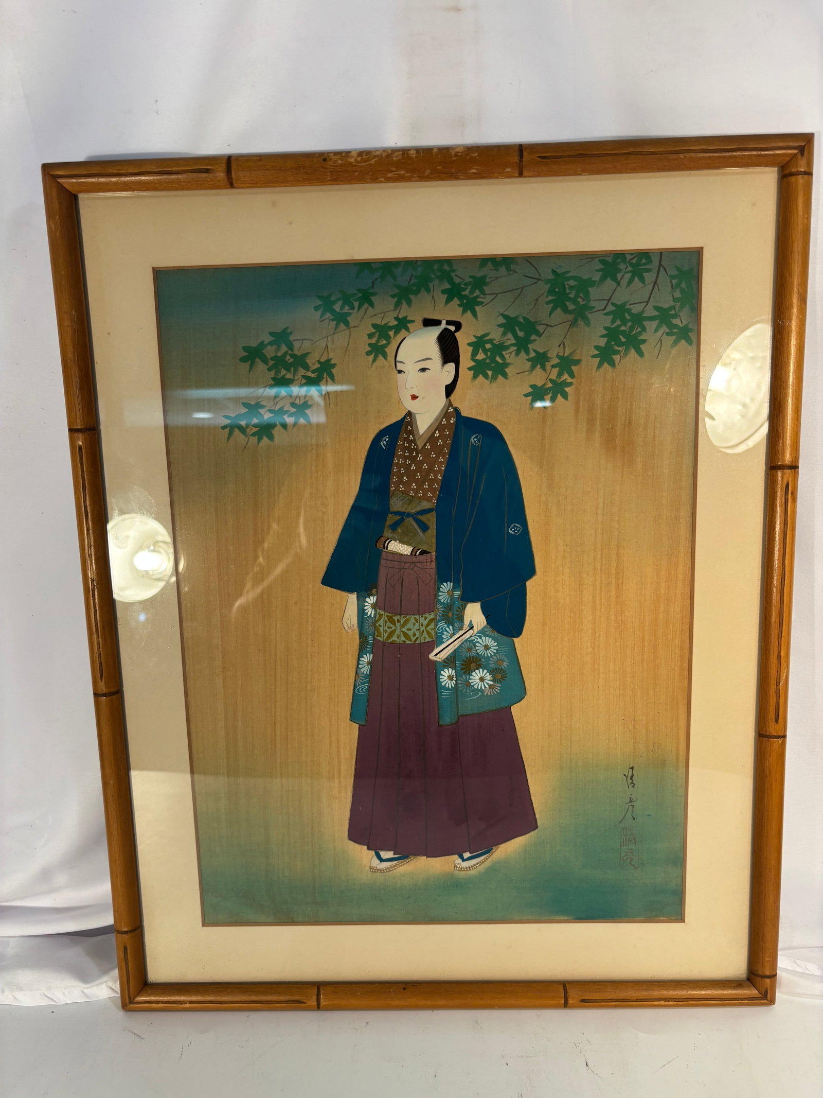 Japanese School Portrait of a Young Samurai, Bearing the Signature “J?hiko?? (??): A finely executed Japanese hanging scroll depicting a young samurai or noble youth dressed in a formal kimono and haori, standing beneath gracefully cascading maple branches. The figure holds a folded