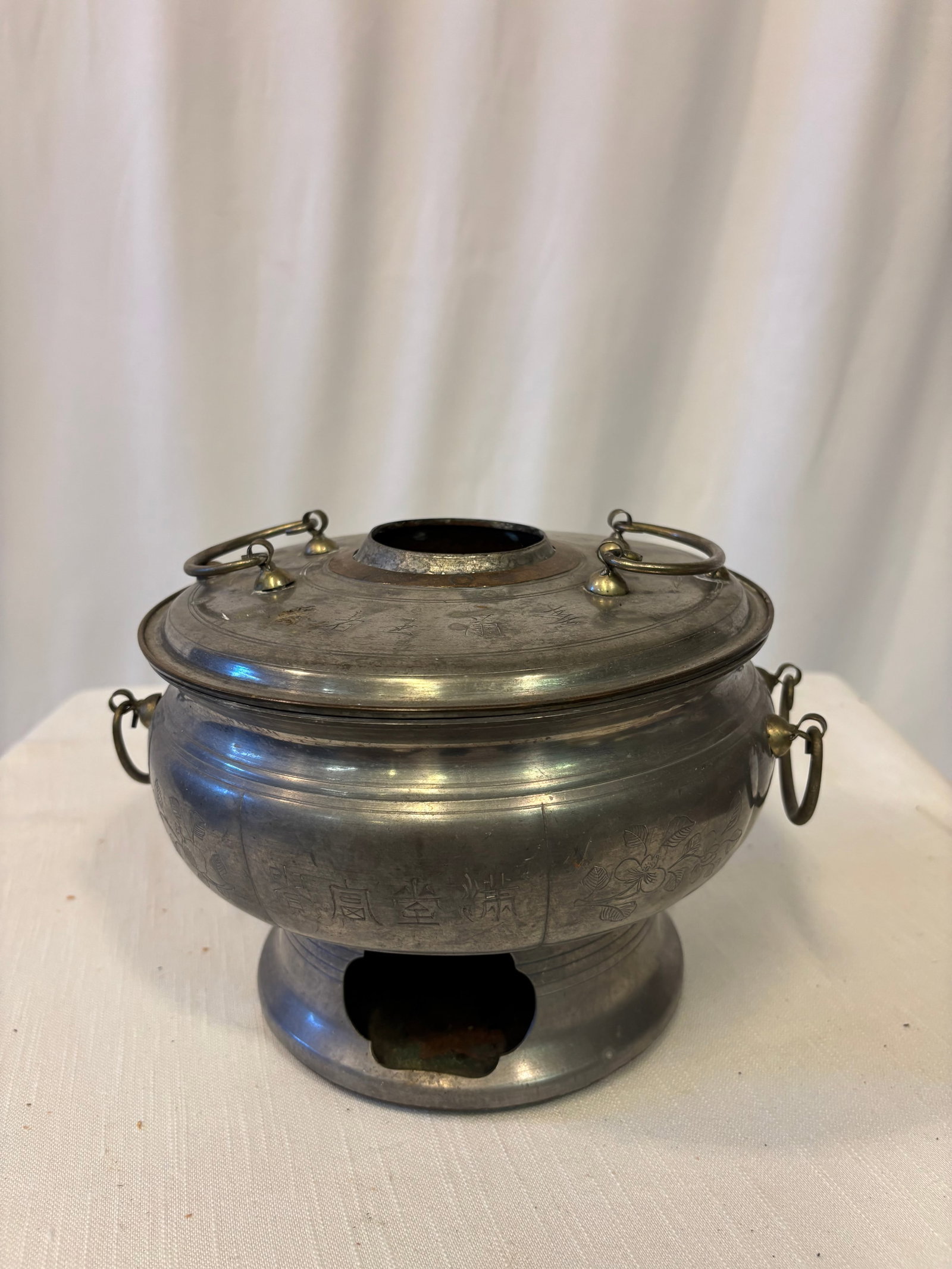 Antique Chinese Engraved Pewter Wine Warmer and Charcoal Hot Pot, Shangyang Mark: An antique Chinese pewter charcoal hot pot and wine warmer of rounded form, fitted with a removable cover, central chimney, and pedestal base with a side opening for the charcoal burner. The exterior 