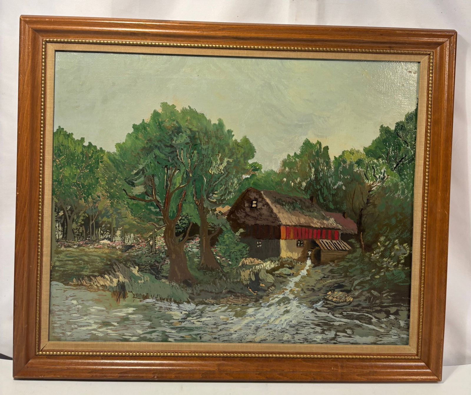 Vintage Post-Impressionist Style Thatched-Roof Watermill Landscape Oil Painting: A vintage oil-on-canvas landscape depicting a rustic thatched-roof watermill or cottage nestled among dense green trees beside a rushing stream. Executed in a Post-Impressionist-influenced style, the 