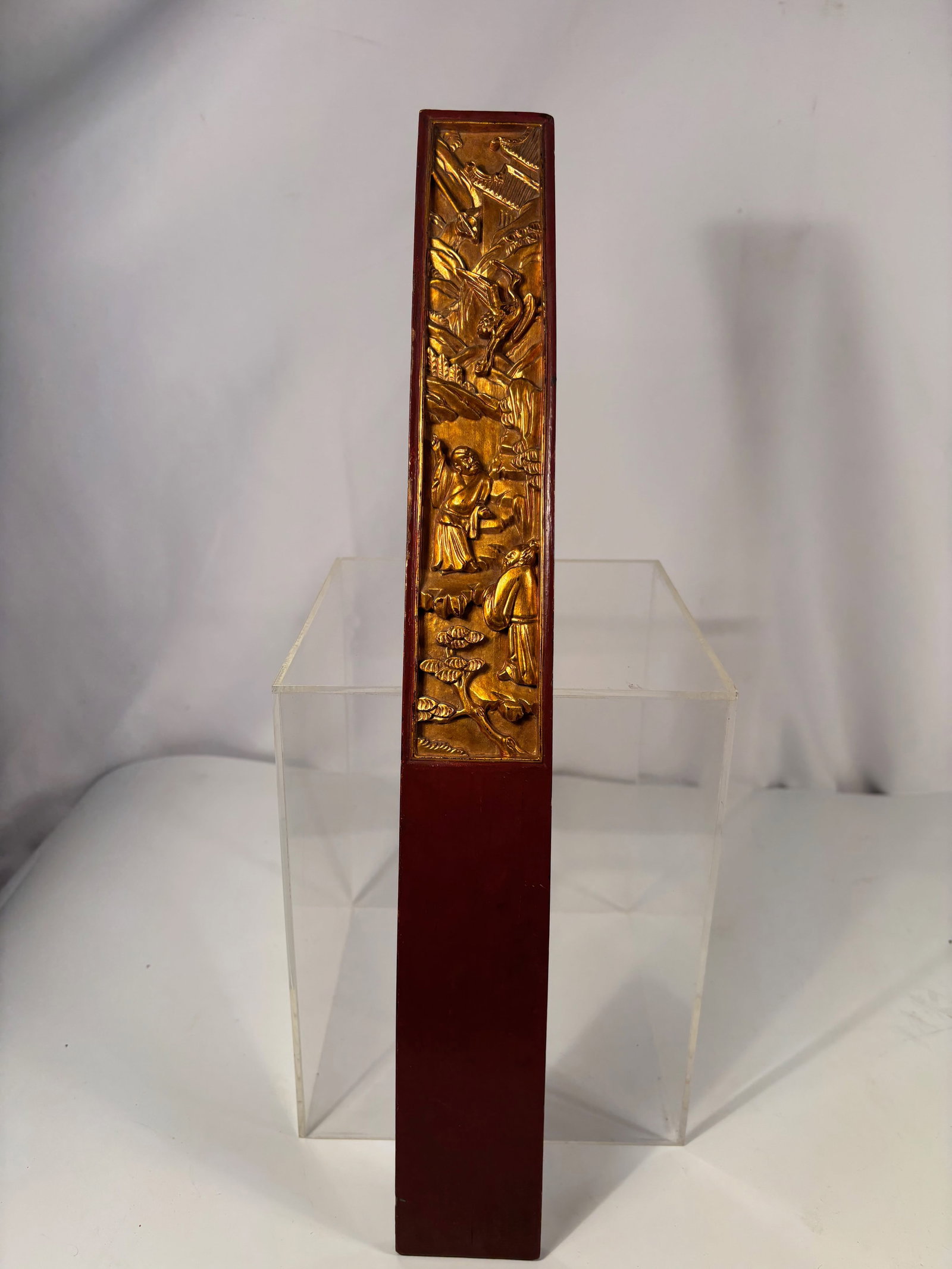 A Chinese Gilt and Lacquered Wooden Court Tablet (Hu Board): Qing dynasty(1644-1912); Finely carved and gilt-lacquered wooden Hu (court tablet) depicting two robed scholars beneath pine trees with a crane flying above, symbolizing wisdom and longevity. The reli