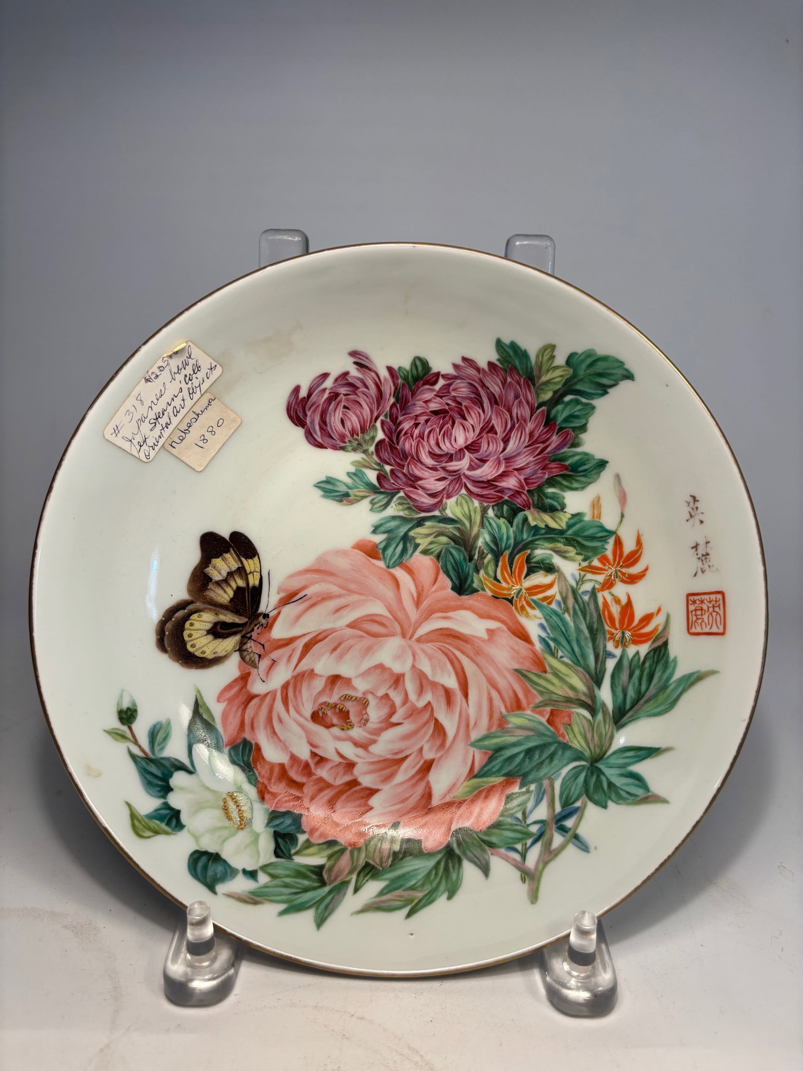 A Japanese Nabeshima Porcelain Plate , Signed Hisami, Hizen Official Kiln, Stearns Collection: Meiji Period ( Dated 1880 ) ,The plate is exquisitely decorated in vibrant overglaze enamels with detailed chrysanthemums, orange lilies, and a butterfly hovering over peony blossoms, all set against 