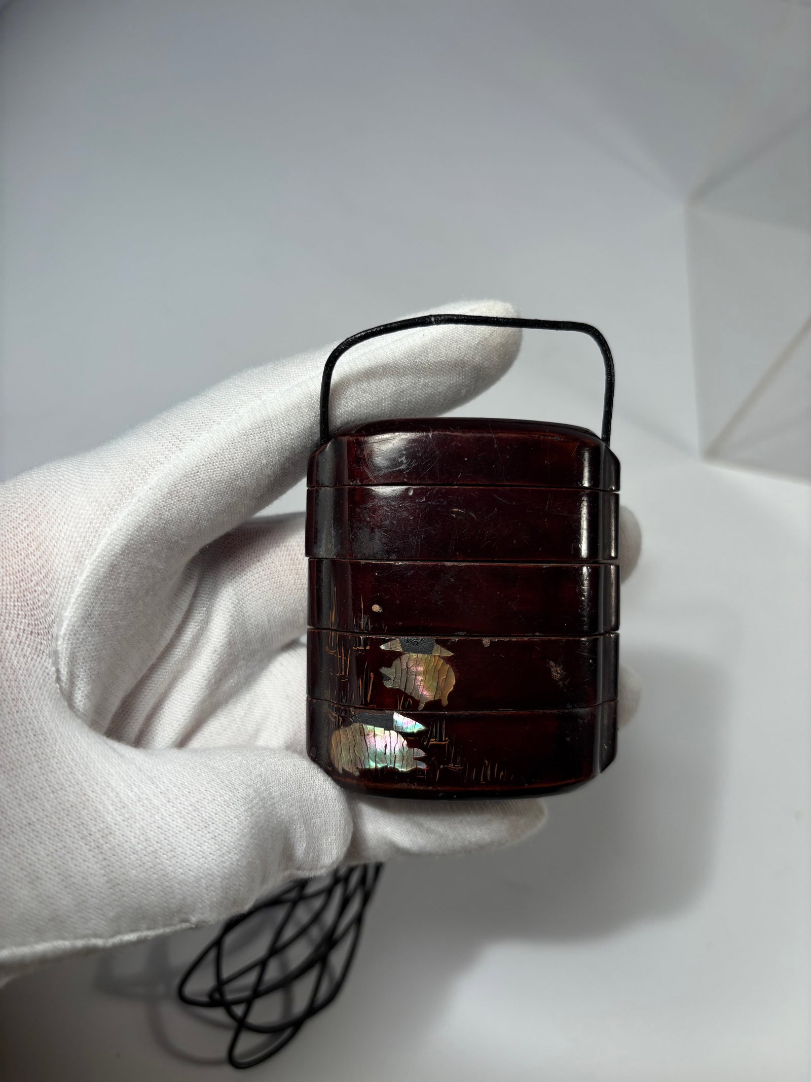 A Japanese Lacquer Four-Case Inr? with Grasshopper Motif and Mother-of-Pearl Inlay: Meiji period (1868–1912);A four-case inr? of dark brown lacquer, decorated in maki-e with gold highlights and raden (mother-of-pearl inlay), depicting a grasshopper among foliage. The compartments
