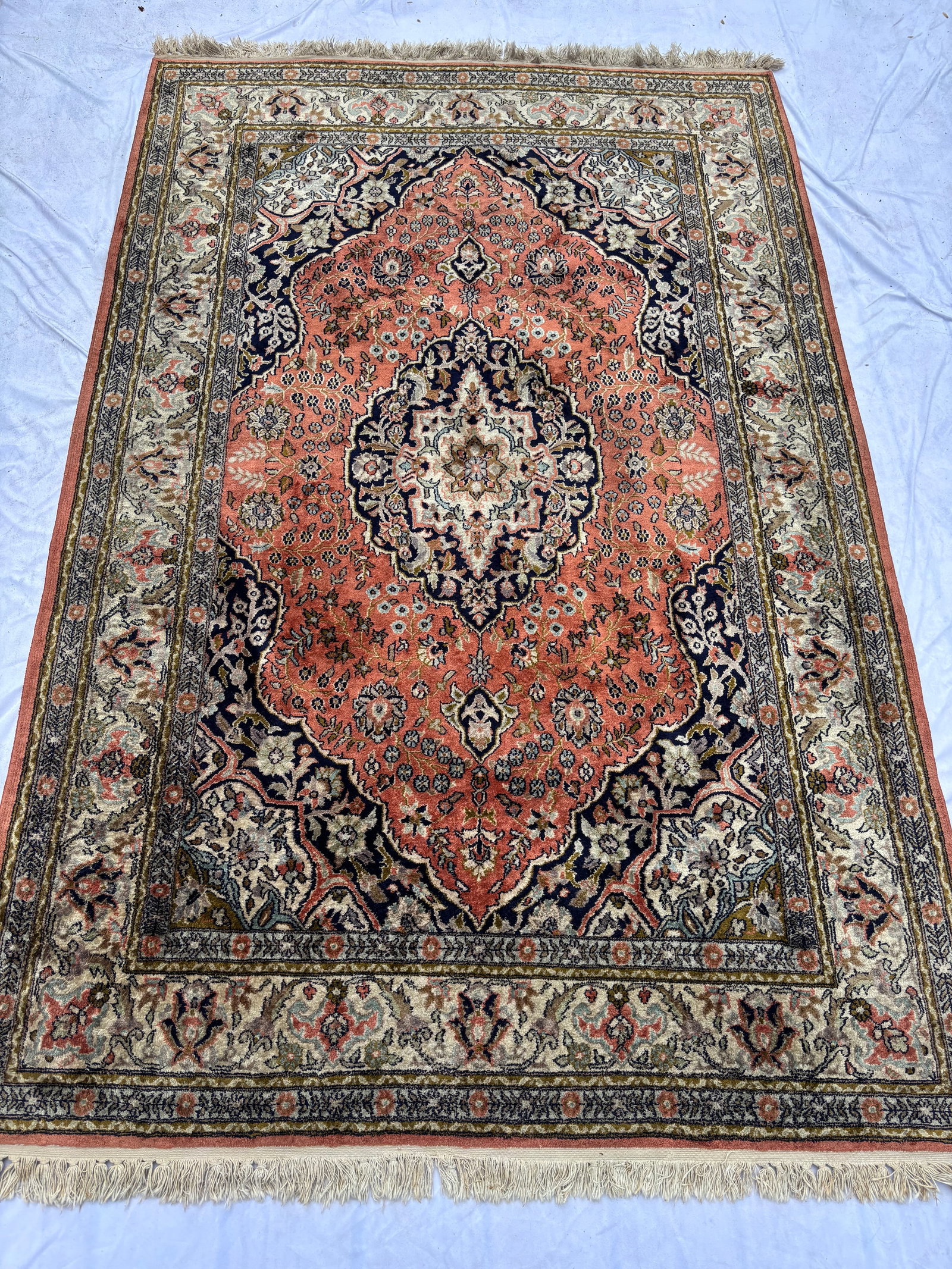Hand-Knotted Persian Silk Tabriz Style Area Rug: Finely hand-knotted Persian silk Tabriz-style area rug featuring an elaborate floral medallion design in salmon, ivory, navy, and soft earth-tone colors. Exceptionally detailed weave with scrolling fl