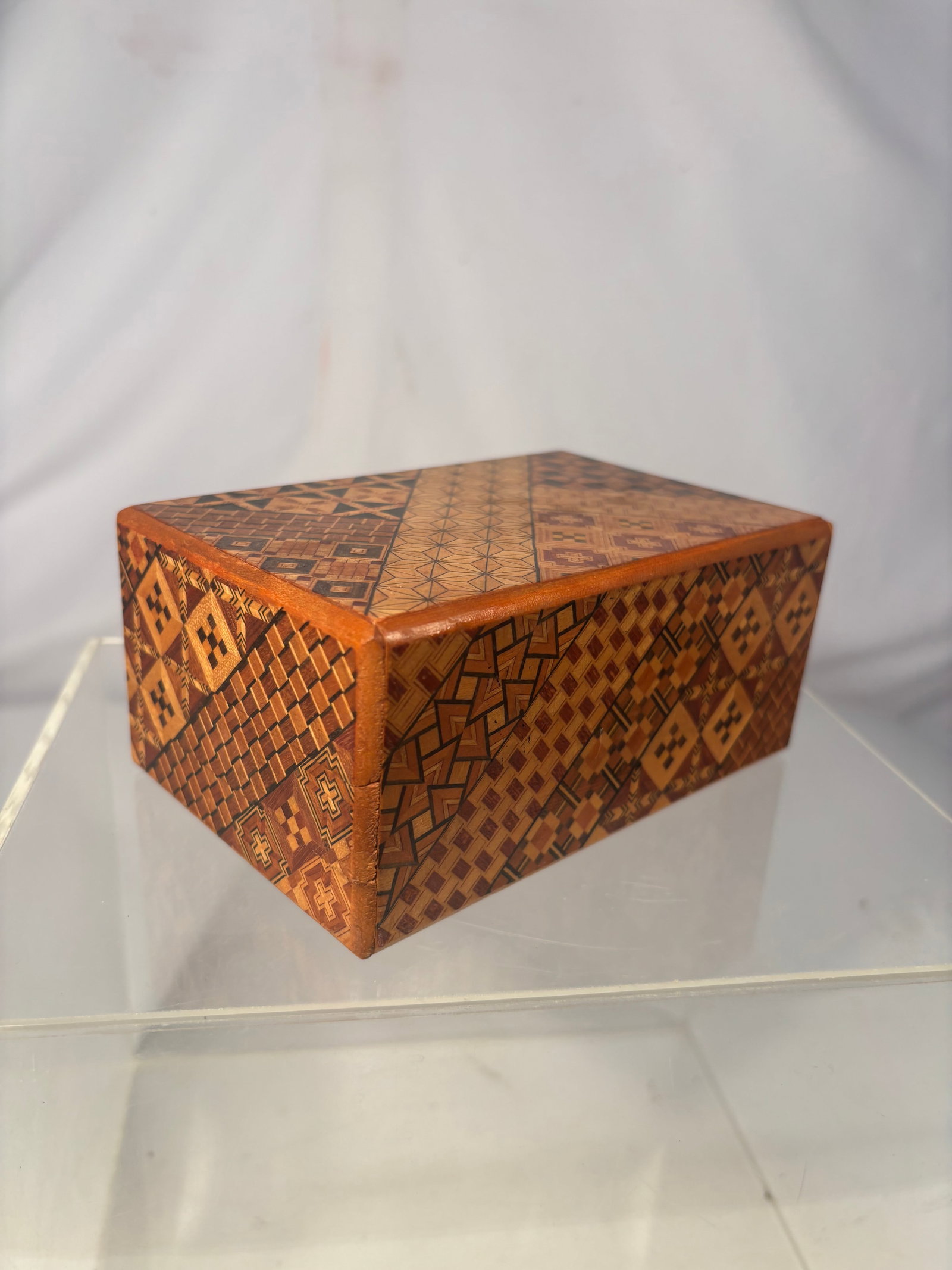 Vintage Japanese Hakone Yosegi Marquetry Puzzle Box: A vintage Japanese wooden puzzle box, or himitsu-bako, decorated throughout with traditional Hakone yosegi-zaiku geometric marquetry. The rectangular box features numerous contrasting wood patterns as