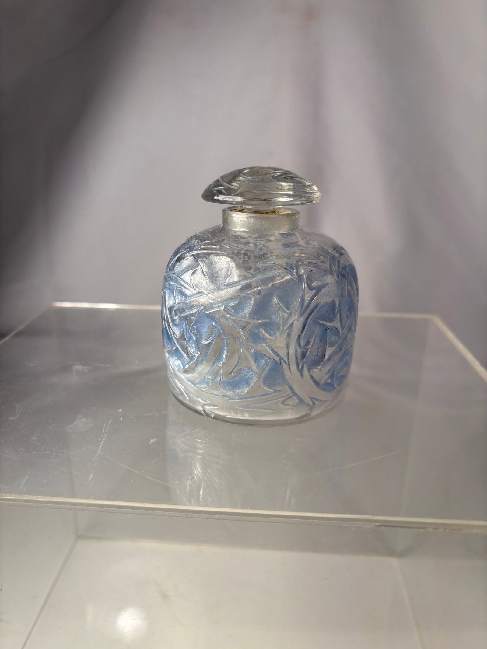 René Lalique “Épines?? Blue-Patinated Glass Perfume Bottle, Designed 1920: A French Art Deco Épines perfume bottle by René Lalique (1860–1945), designed in 1920. The clear molded glass body and matching stopper feature a stylized radiating thorn motif, highlighted with b