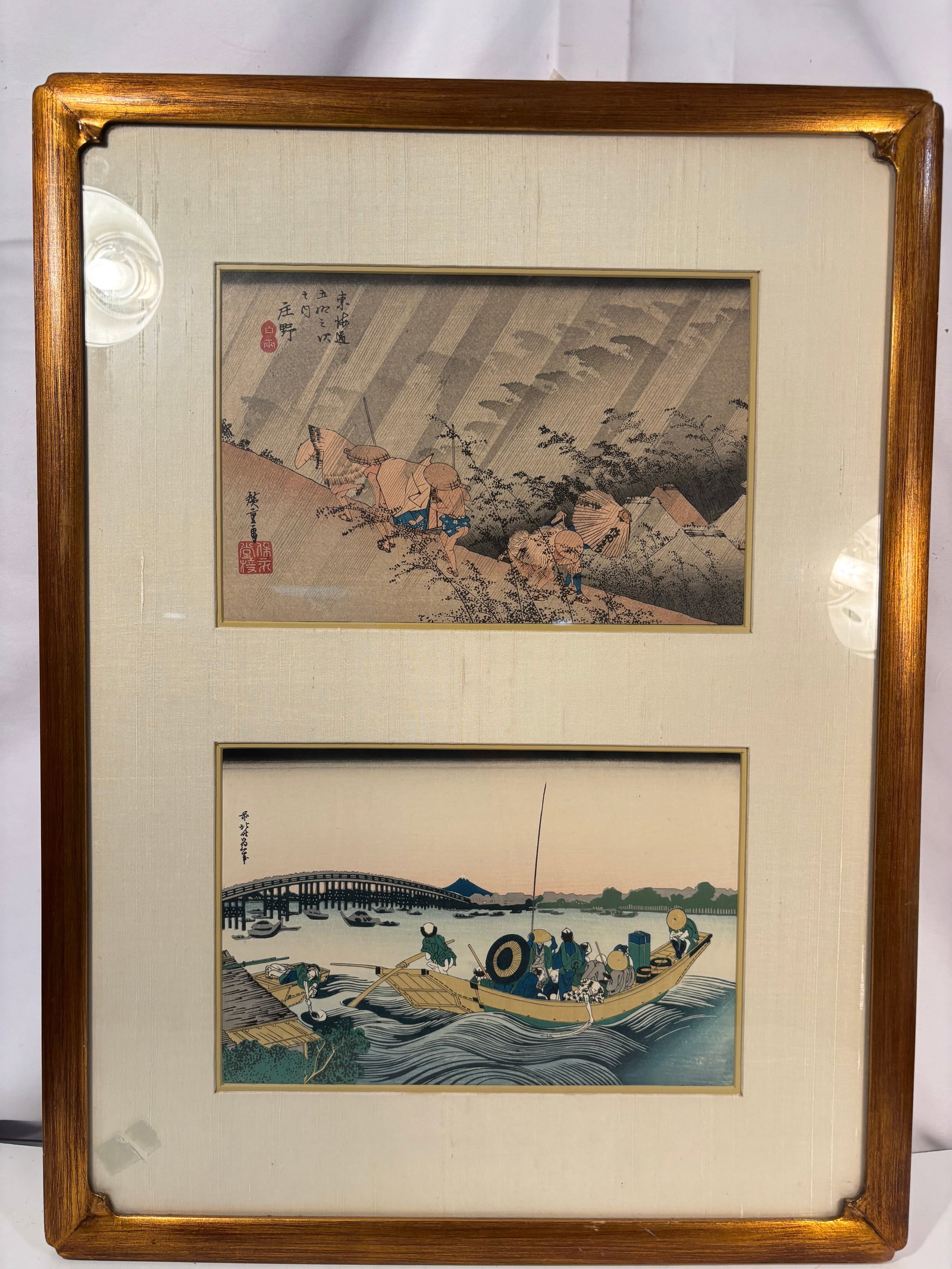 Framed Pair of Japanese Woodblock Prints after Hokusai and Hiroshige: A pair of Japanese color woodblock prints presented together in a giltwood frame.The upper print is after Utagawa Hiroshige (1797–1858), depicting Sh?no: Driving Rain from the celebrated series The 