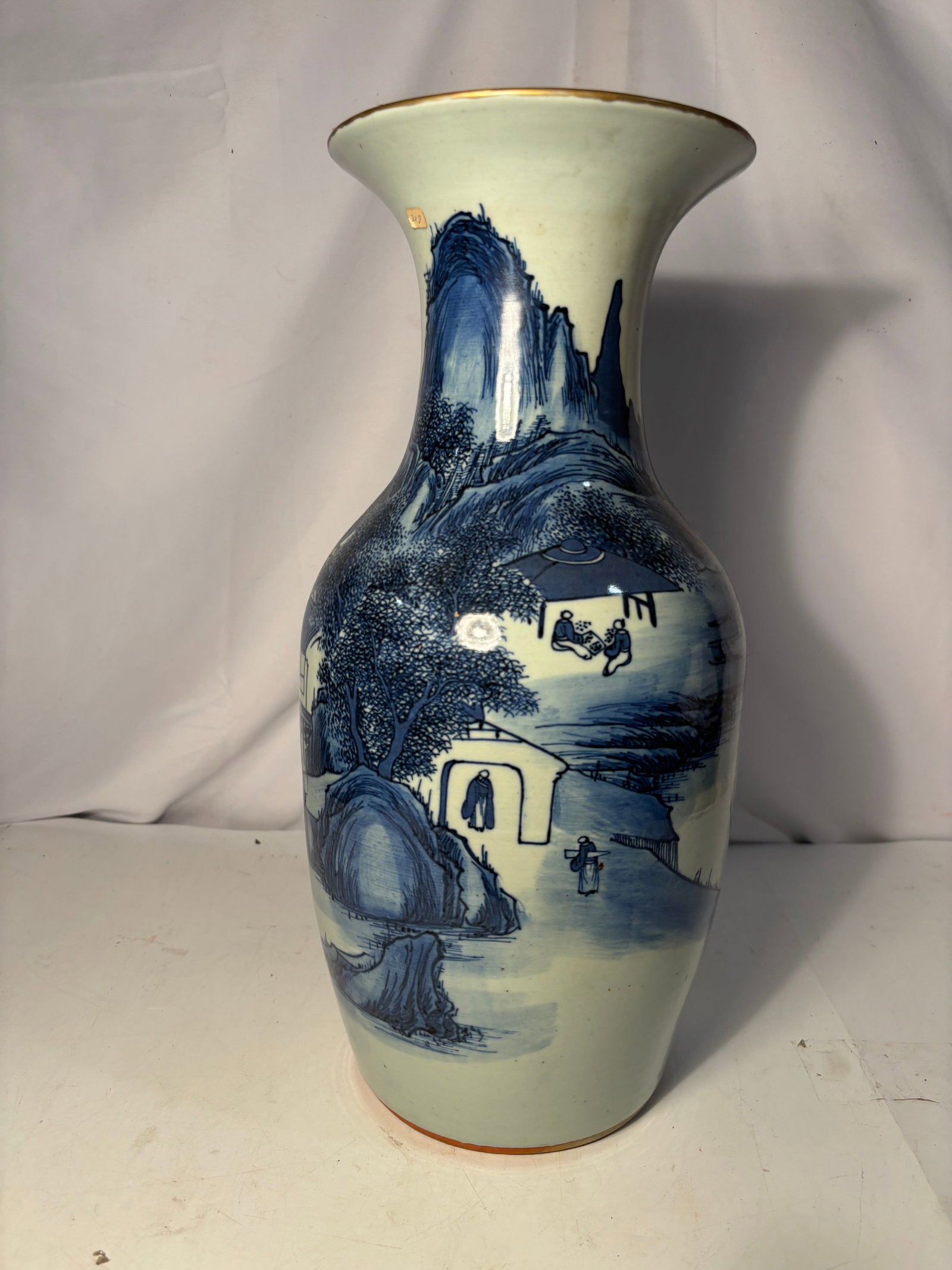 Chinese Blue and White Celadon-Ground Landscape Porcelain Vase Qing Dynasty(1644-1912): A Chinese porcelain baluster vase with a tall flaring neck, covered in a pale celadon-toned glaze and freely painted in underglaze cobalt blue. The continuous mountainous landscape includes traditiona