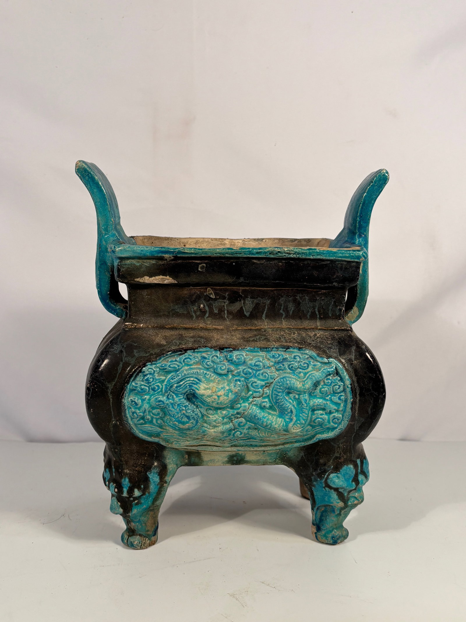 A Turquoise-Glazed Archaistic Tripod Censer (Fang Ding) ,Ming Dynasty(1368-1644): Ming Dynasty(1368-1644); Of square ding form, supported on four cabriole feet and flanked by upright loop handles, the sides molded with dragons amidst swirling clouds. Covered overall with a vivid tu