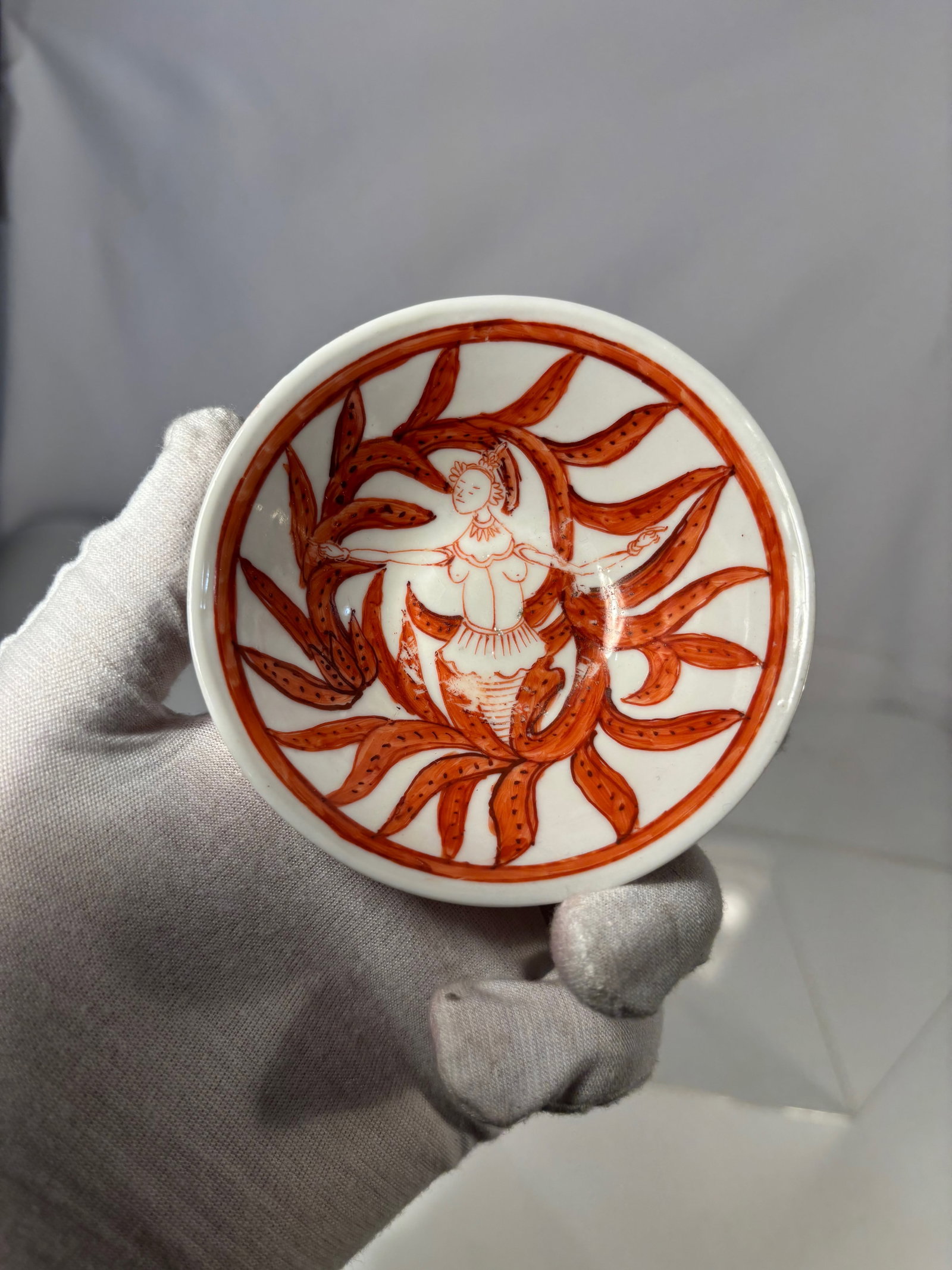 Chinese Iron Red Porcelain Bowl with Figural and Floral Decoration: 18th century, A Chinese porcelain bowl decorated in iron red with continuous figural and scrolling floral motifs around the exterior. The interior is plain white. The base is unglazed within the foot 