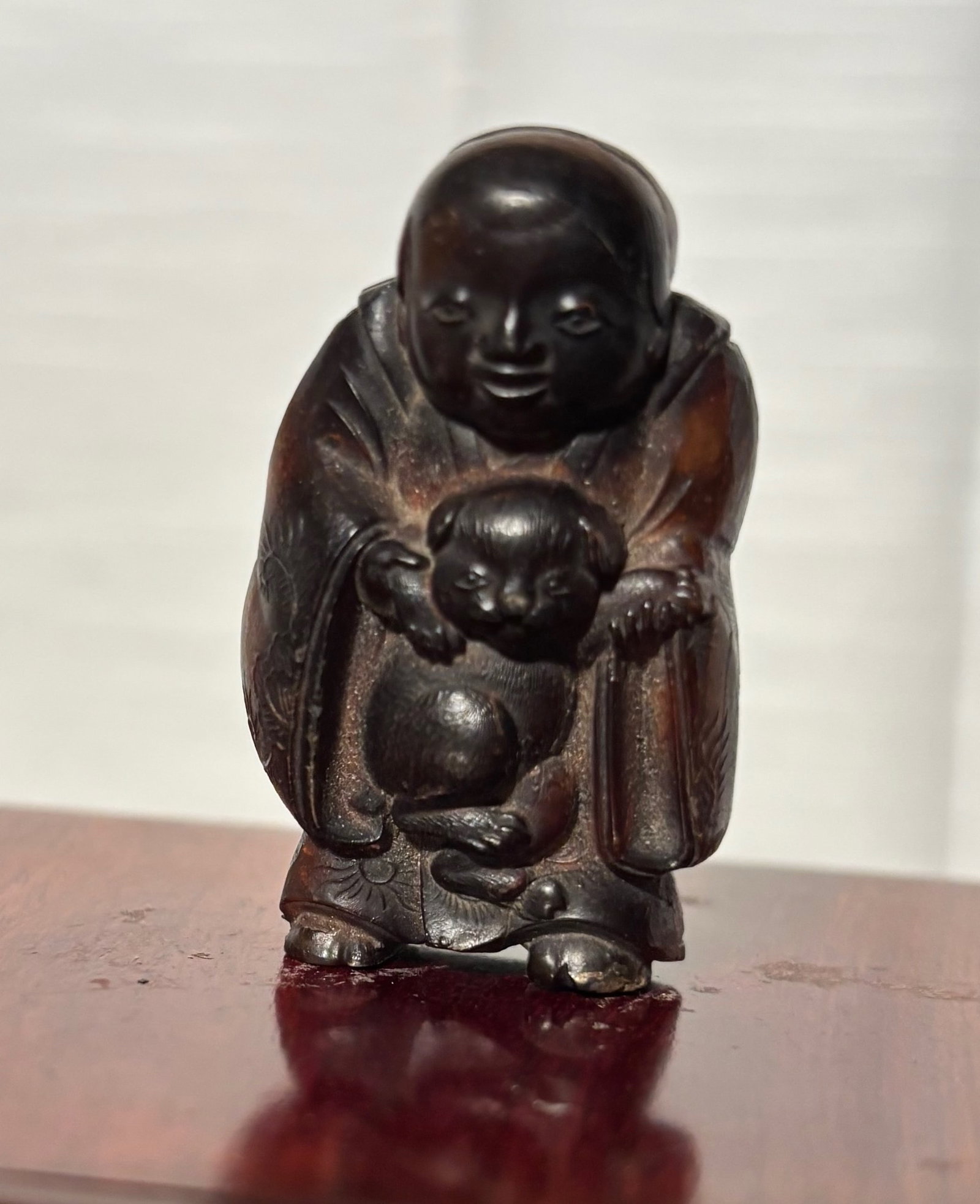 A Japanese Carved Hotei (Budai) Figure Holding Child, Possibly Horn (1 of 8)