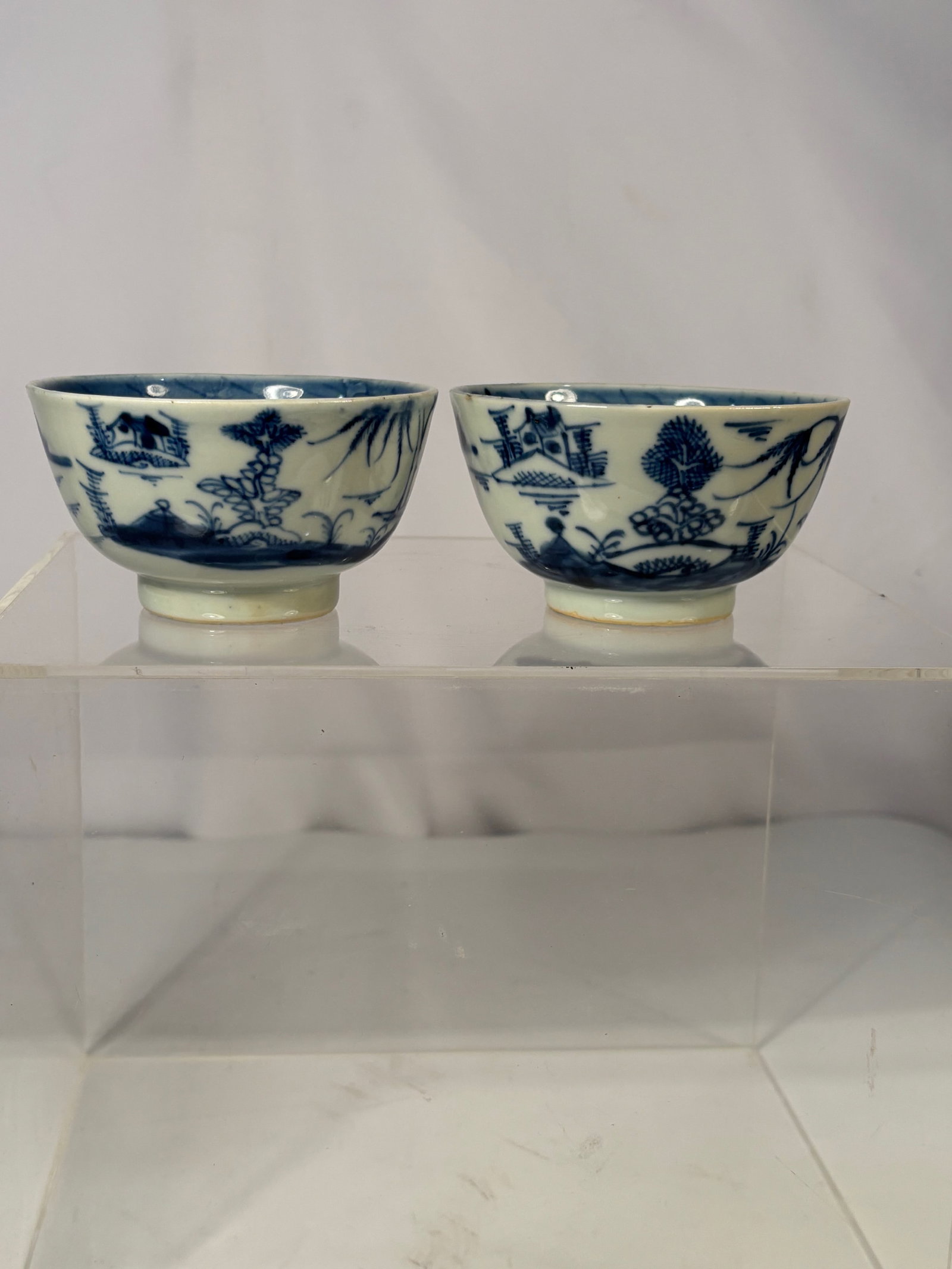 Pair of Chinese Blue and White porcelain Landscape Bowls: Qing dynasty(1644-1912) ; A pair of late Qing dynasty blue and white porcelain bowls painted with landscape scenes of pavilions, trees, and riverbanks. The bowls feature a soft bluish glaze and
