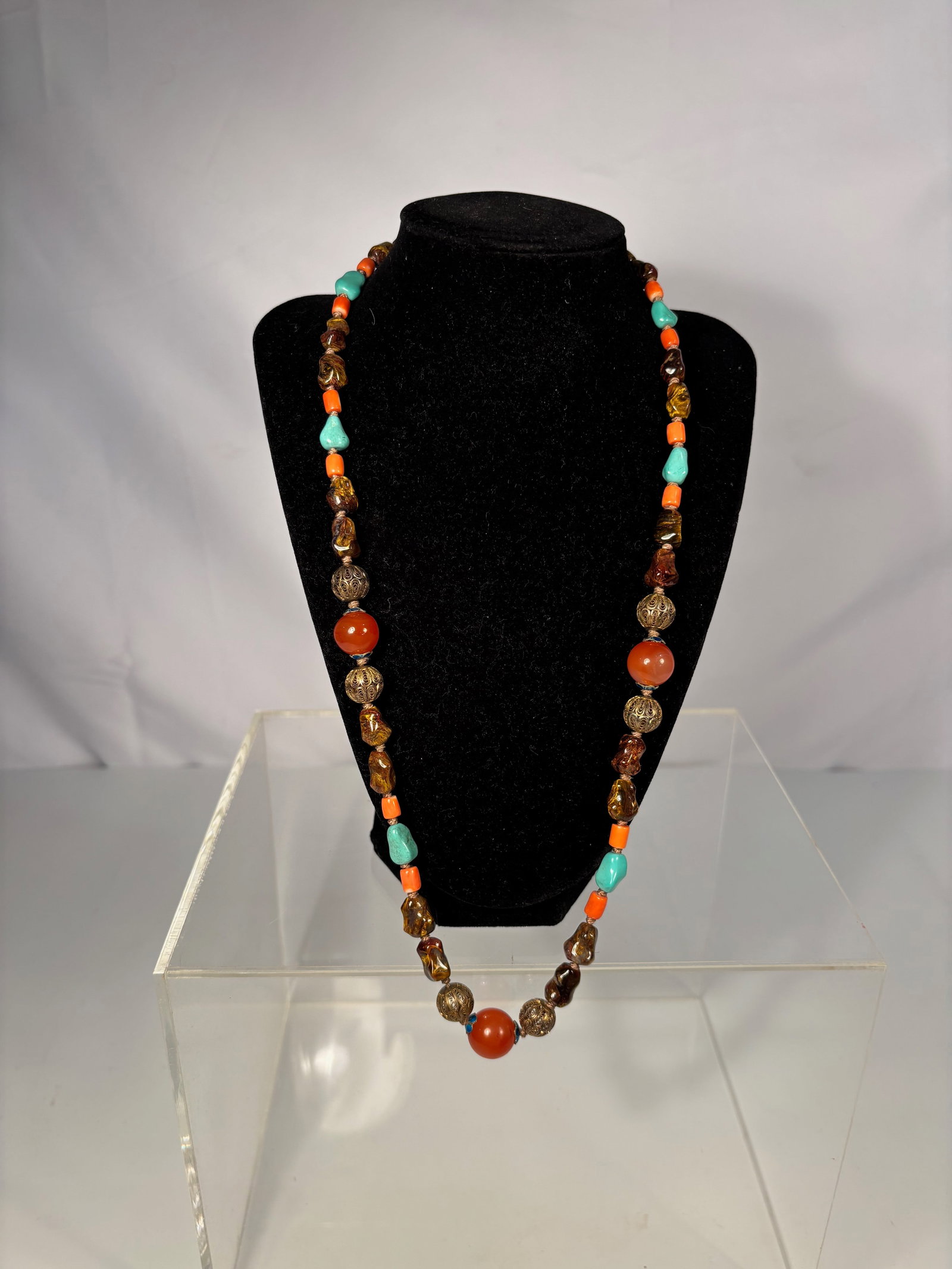 Chinese Necklace with Coral, Turquoise, Carnelian, and Tiger’s Eye Beads with Gilt silver Spacers: A Chinese necklace composed of mixed beads including small barrel-shaped coral, rough turquoise nuggets, translucent carnelian (red agate) beads, and golden-brown tiger’s eye stones, interspersed wi