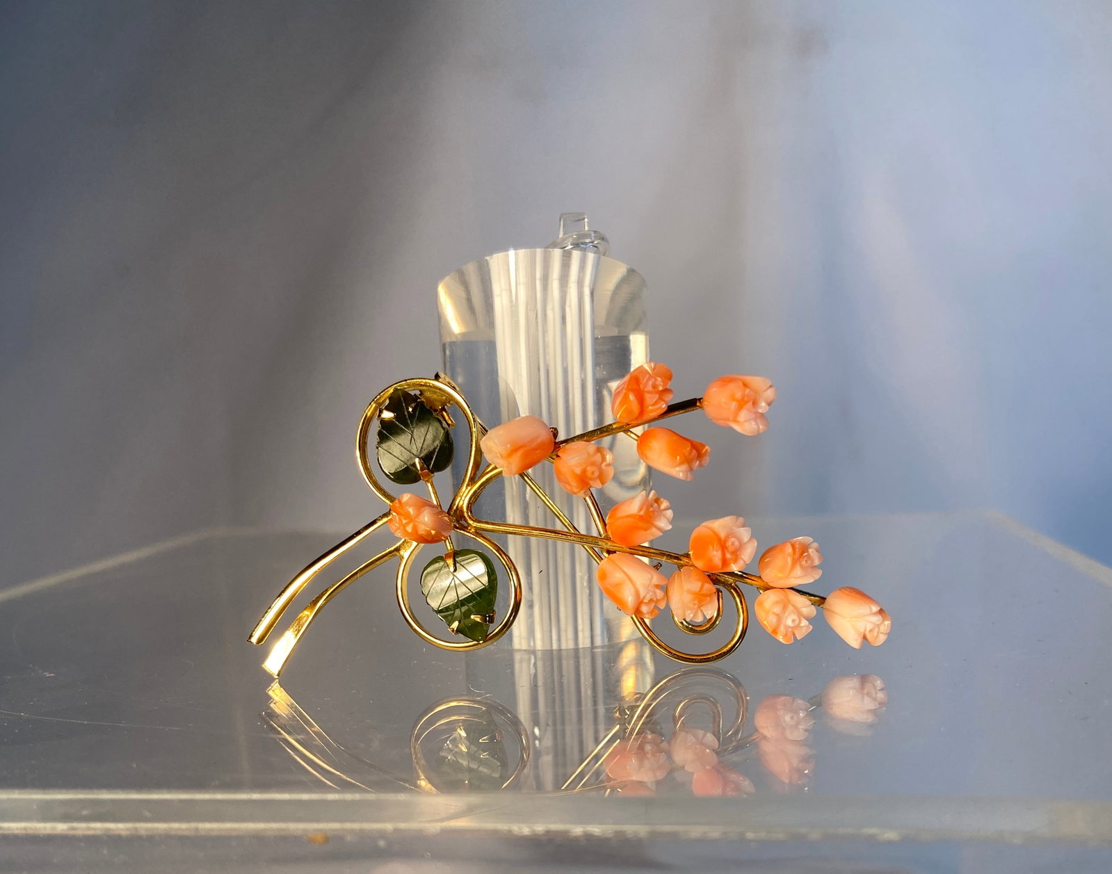 Vintage Carved Coral Floral Brooch: Vintage floral form brooch featuring carved pink coral rosebuds with green leaf accents mounted in gold-tone metal. Delicate bouquet design with dimensional carved details. Approximately 3” H x 