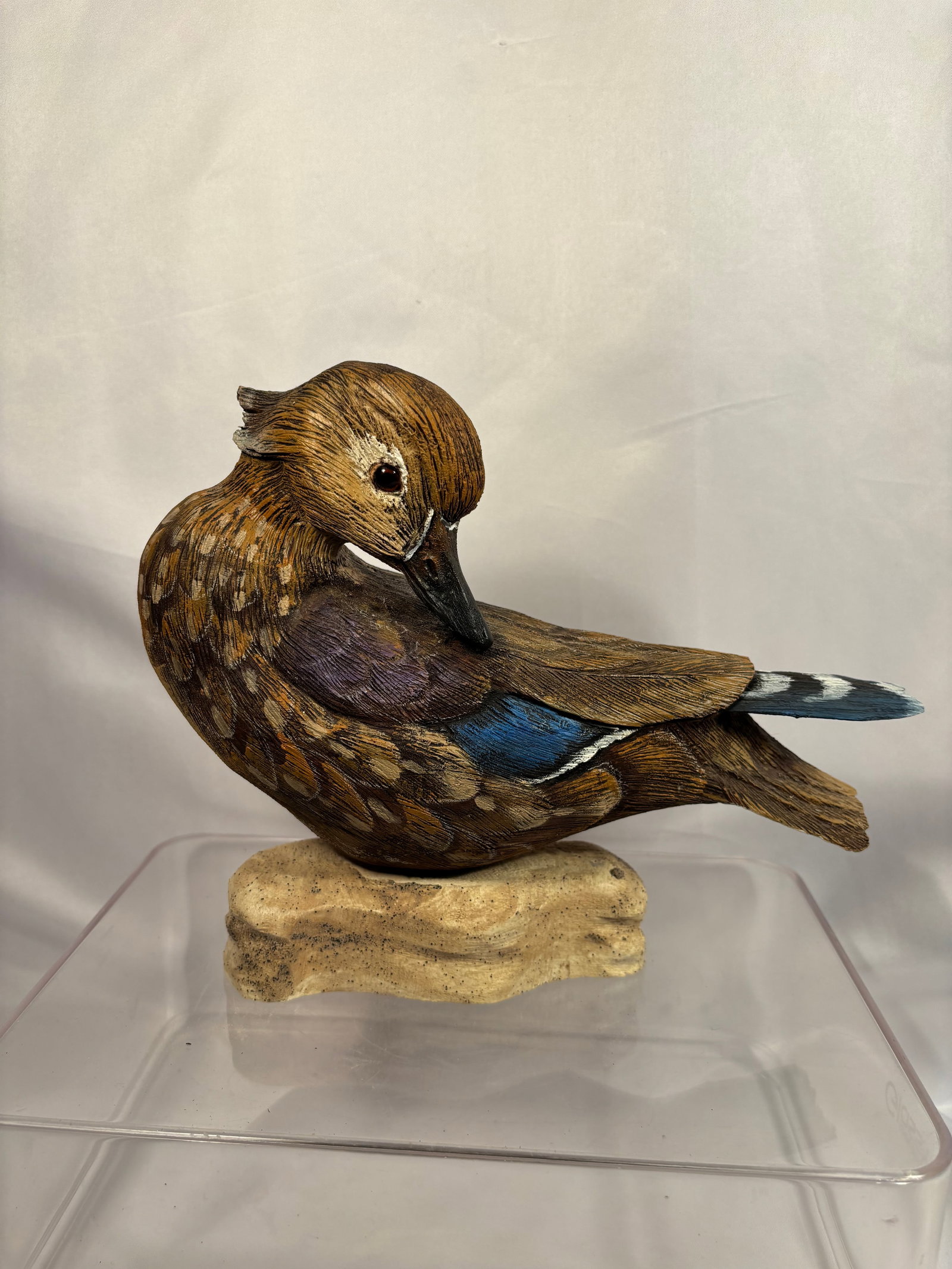 Charles Burns Signed 2000 Carved and Painted Wood Duck Sculpture: A detailed carved and hand-painted sculpture depicting a preening female Wood Duck, realistically rendered with layered feather carving and colorful blue and purple wing markings. Mounted on a carved 