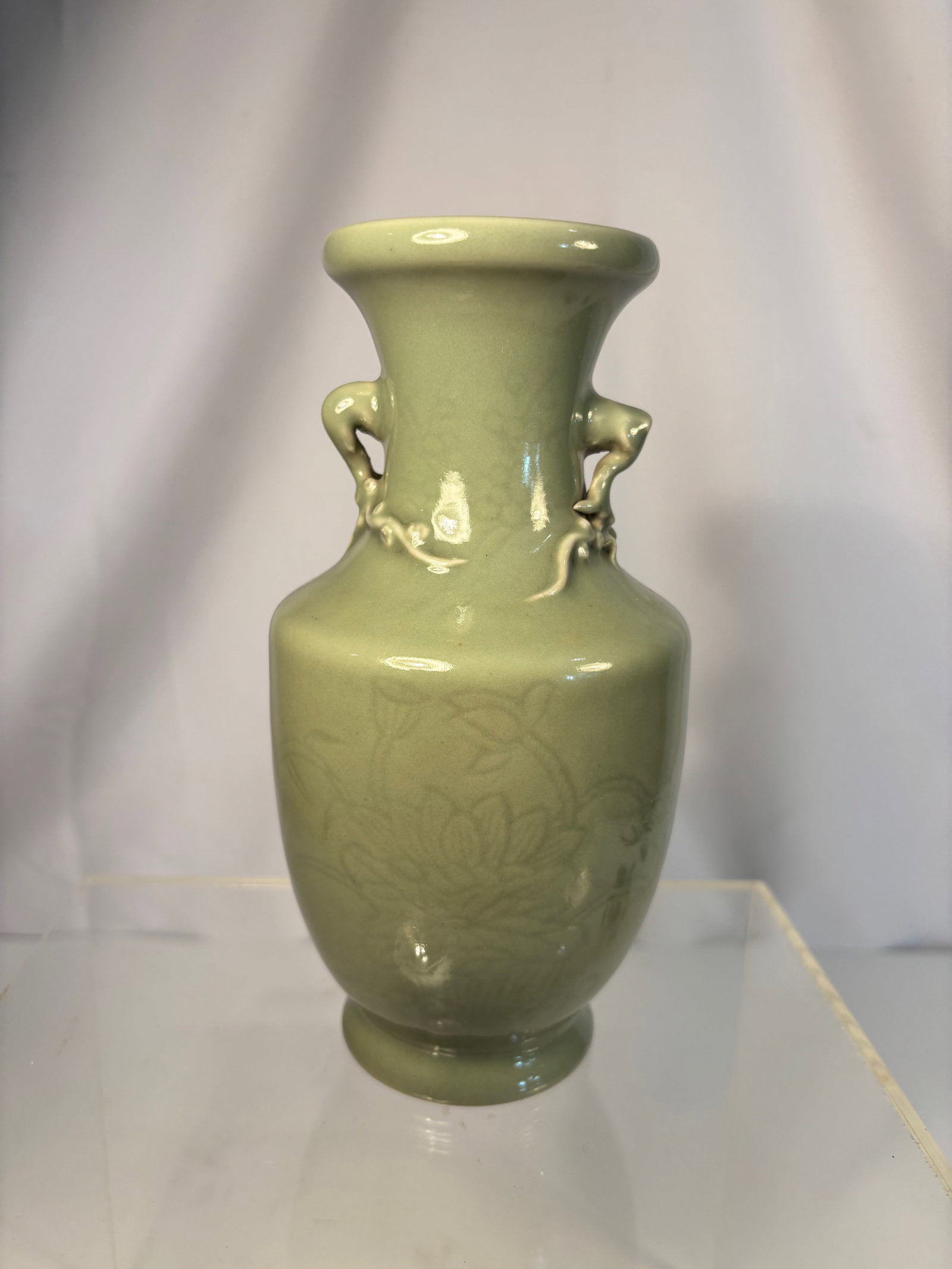 A Chinese Celadon-Glazed Vase with Handles, Qianlong Mark: Qing dyansty(1644-1912); A superb celadon-glazed porcelain vase, elegantly potted with a rounded body rising to a slightly flared neck, flanked by a pair of well-modeled handles in relief. The exterio