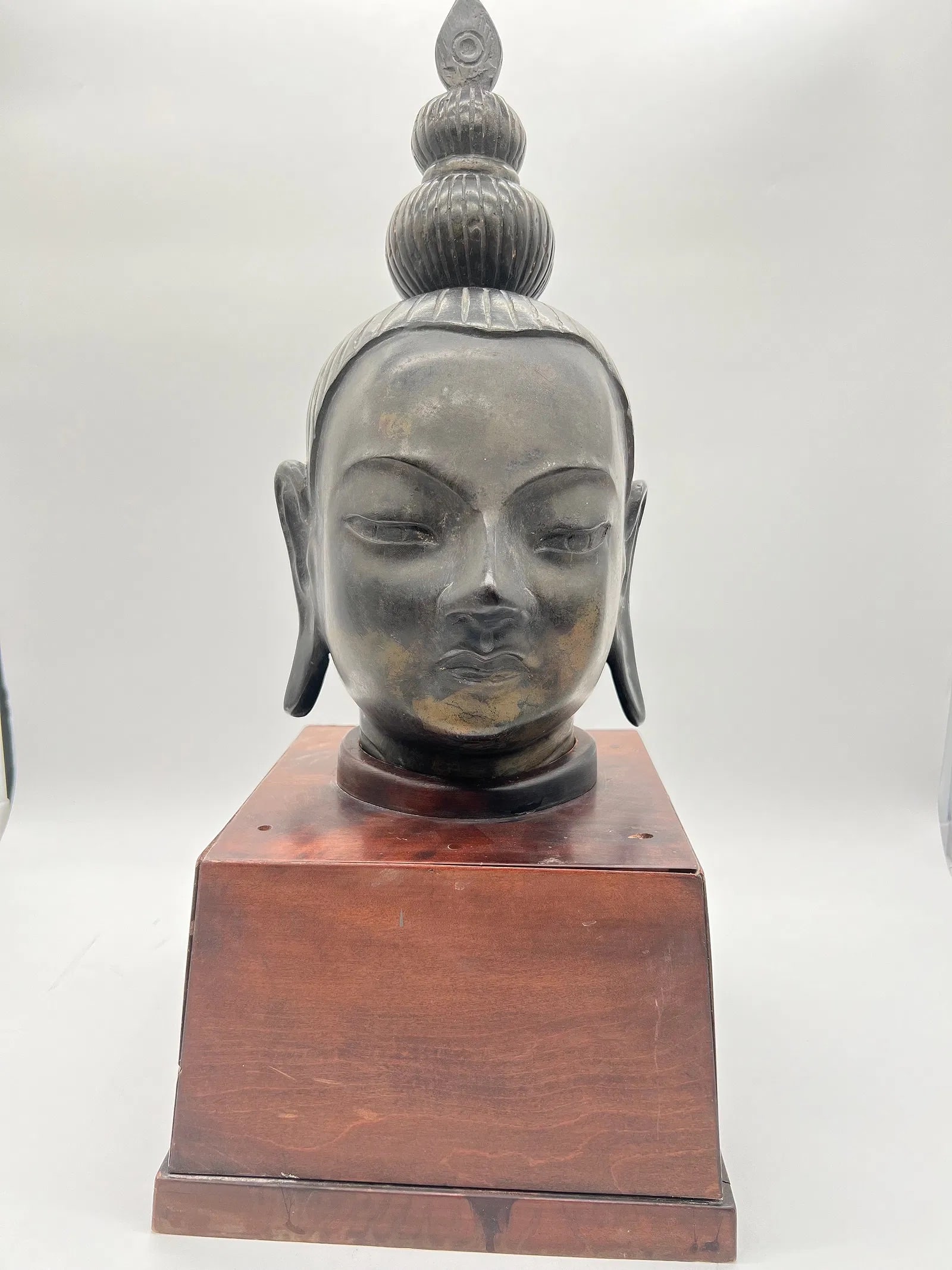 Gilt Bronze Bust of Shakyamuni Buddha with wood stand: Late 19th century or early 20th century ; A beautiful depicted version of Siddhartha Gautama . Wonderful worn gilt bronze patina, with the perfect amount of wear and a contemplative. Dimensions?Total 