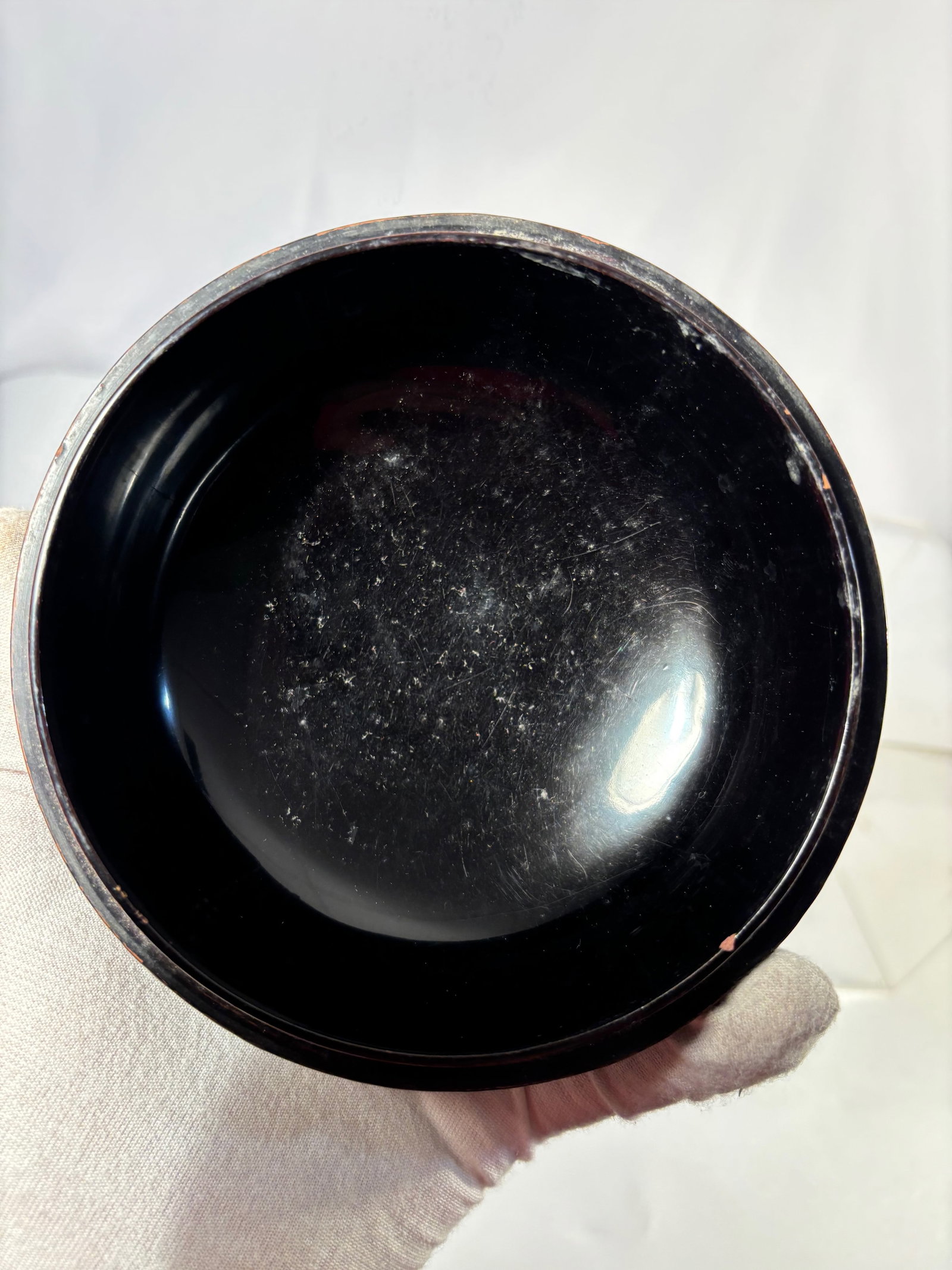 A Japanese Lacquered Wood Bowl with Copper Wire Inlay and Gilt Engraved Decoration, Early Meiji: A finely crafted Japanese black lacquered wood bowl inlaid with delicate copper wire forming interlocking geometric and floral patterns, enhanced with gilt engraving. The refined decoration