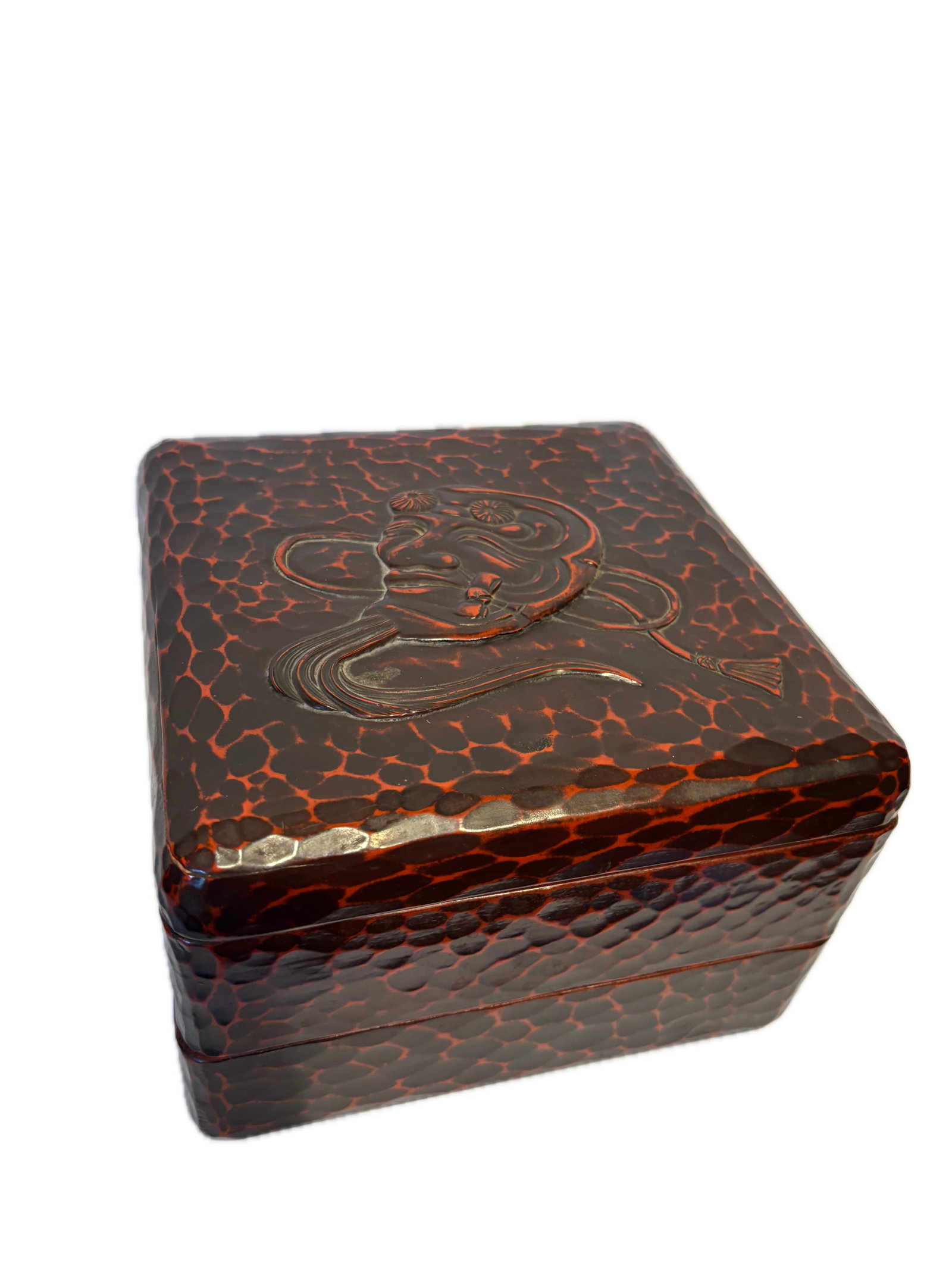 Japanese Red and Black Lacquered Covered Box with Figural Relief Decoration: Japanese lacquered rectangular covered box featuring a striking red and black tortoiseshell-style pattern. The lid is decorated with a molded figural motif, possibly depicting a traditional theatrical