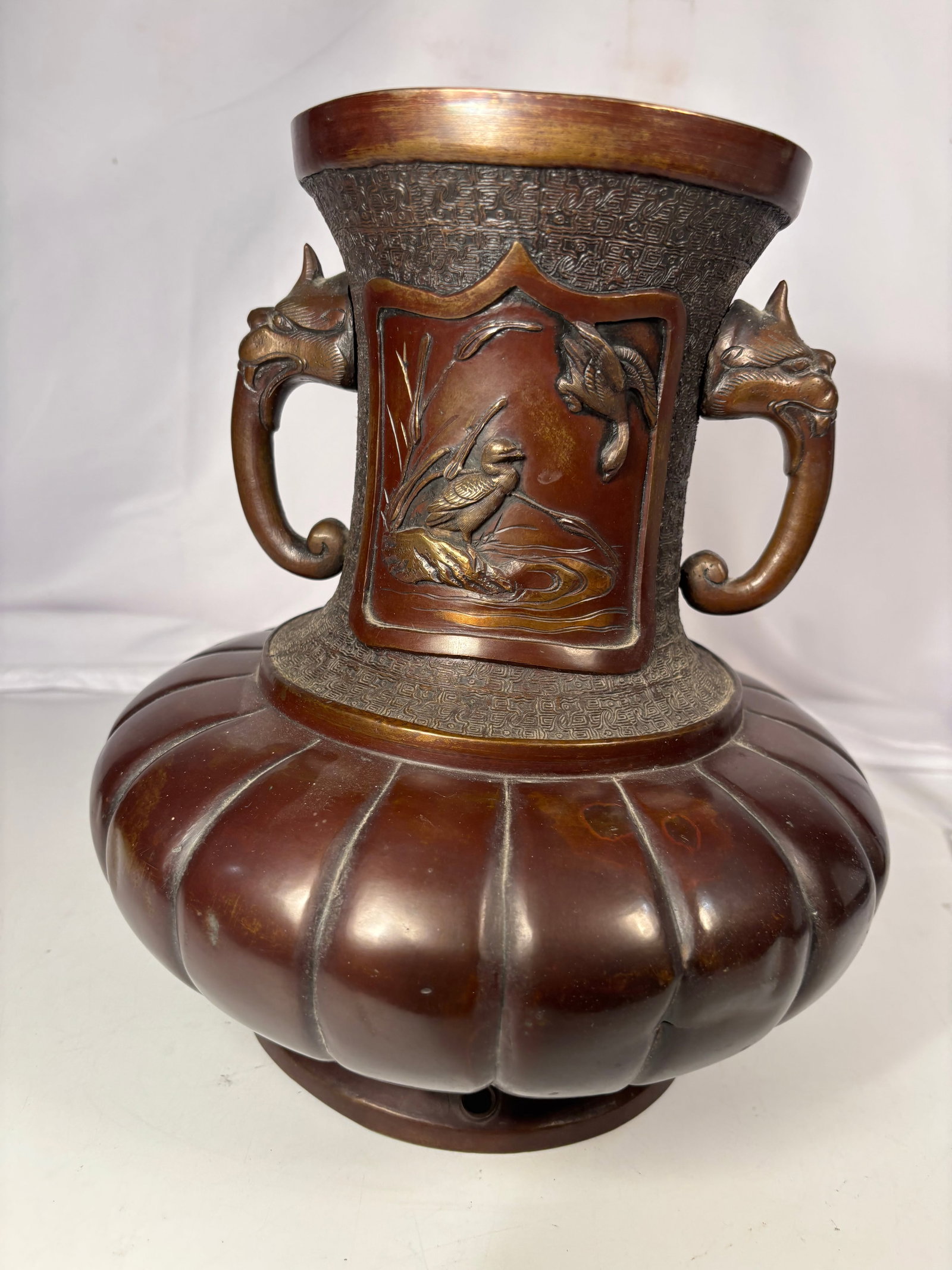 Japanese Bronze Double-Handled Relief Vase with Birds & Fish Motifs , Meiji Period (1868–1912?: A finely crafted Japanese bronze vase in the Meiji style, featuring a lobed baluster body and a flared neck with a pair of mythical beast-form handles. The body is decorated with high-relief panels de