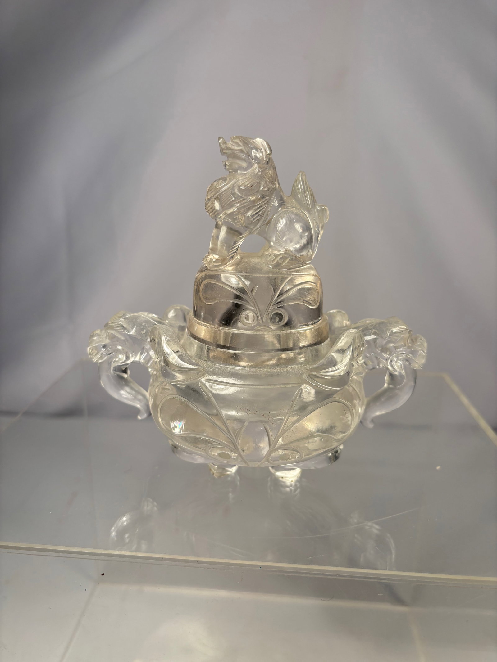 A Chinese Rock Crystal Censer with Carved Lion Finial: Qing dynasty(1644-1912); Carved from clear rock crystal, the censer is of rounded form with scrolling handles at the sides. The domed cover is surmounted by a finely carved lion (foo dog) finial, deta