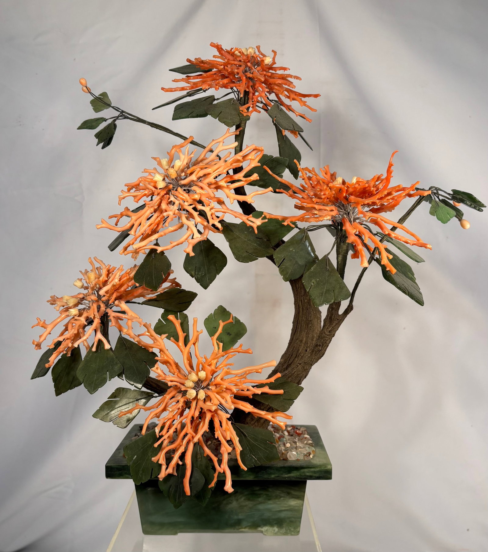 Large Chinese Carved Natural Coral and Jade Flowering Tree Sculpture: A finely crafted vintage Chinese flowering-tree sculpture featuring five large blossoms composed of numerous hand-carved natural coral branches. The vibrant orange-red coral flowers are surrounded by 
