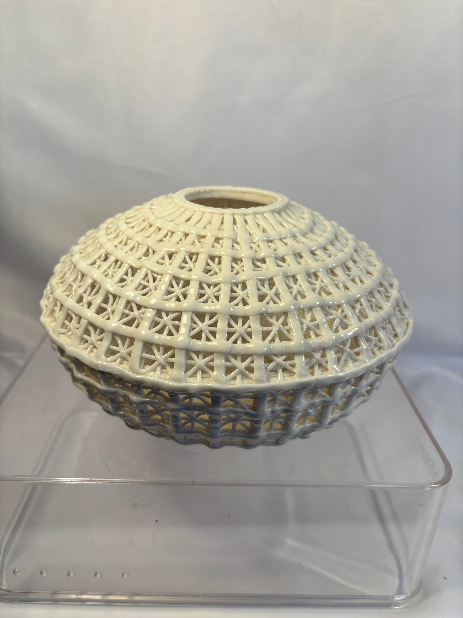 Cyan Design “Diana?? White Open-Weave Ceramic Basket Vase: A Cyan Design “Diana” ceramic vase featuring an intricate open basket-weave construction in a white glazed finish. The compressed globular body is formed with multiple bands of delicate geomet