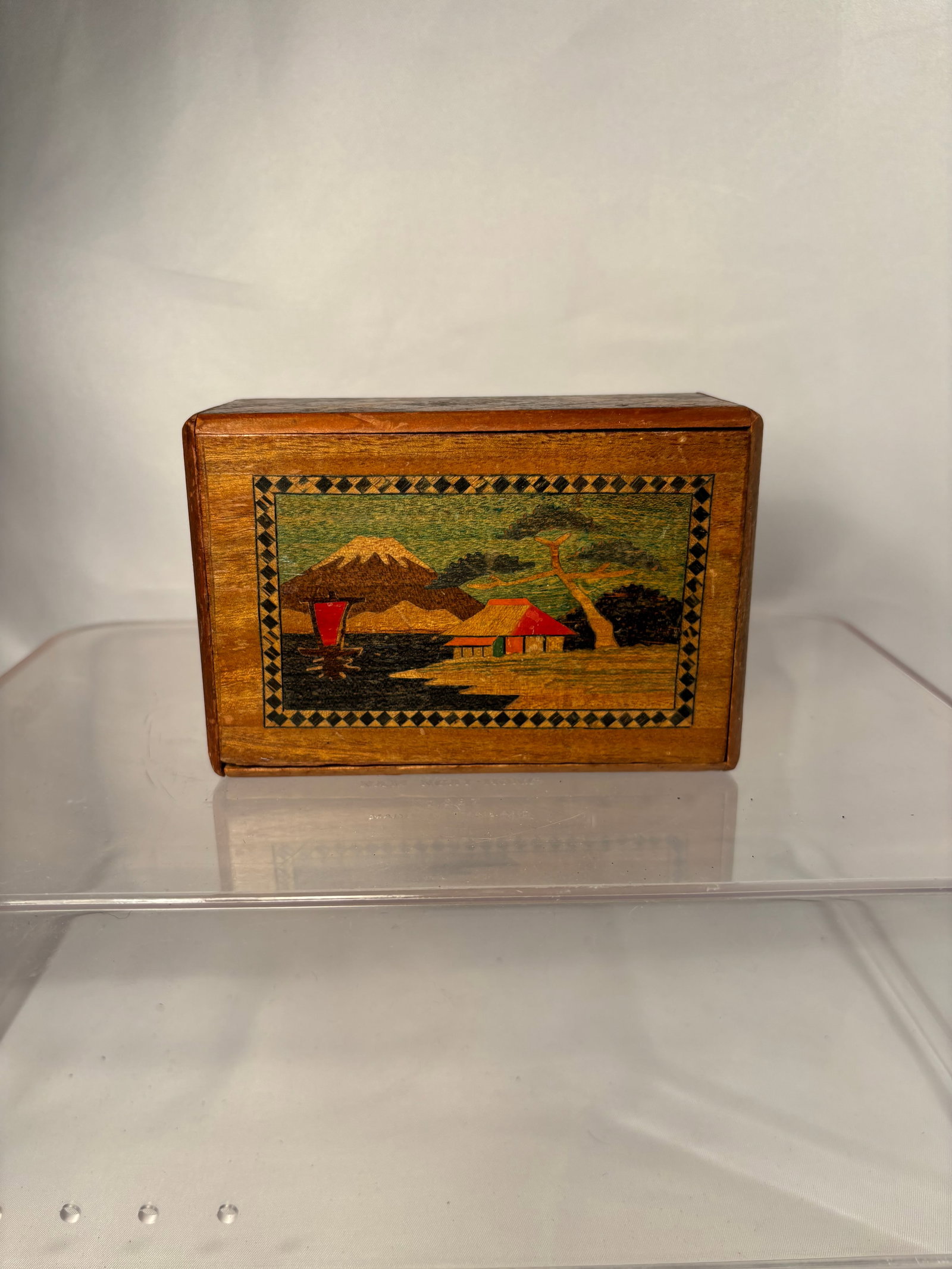 A Vintage Japanese Hakone Yosegi-Zaiku Secret Puzzle Box with Mount Fuji and Camellia: A Japanese wooden secret or puzzle box crafted in the Hakone yosegi-zaiku tradition. The rectangular box is decorated with contrasting wood marquetry, featuring a landscape panel depicting Mount Fuji,
