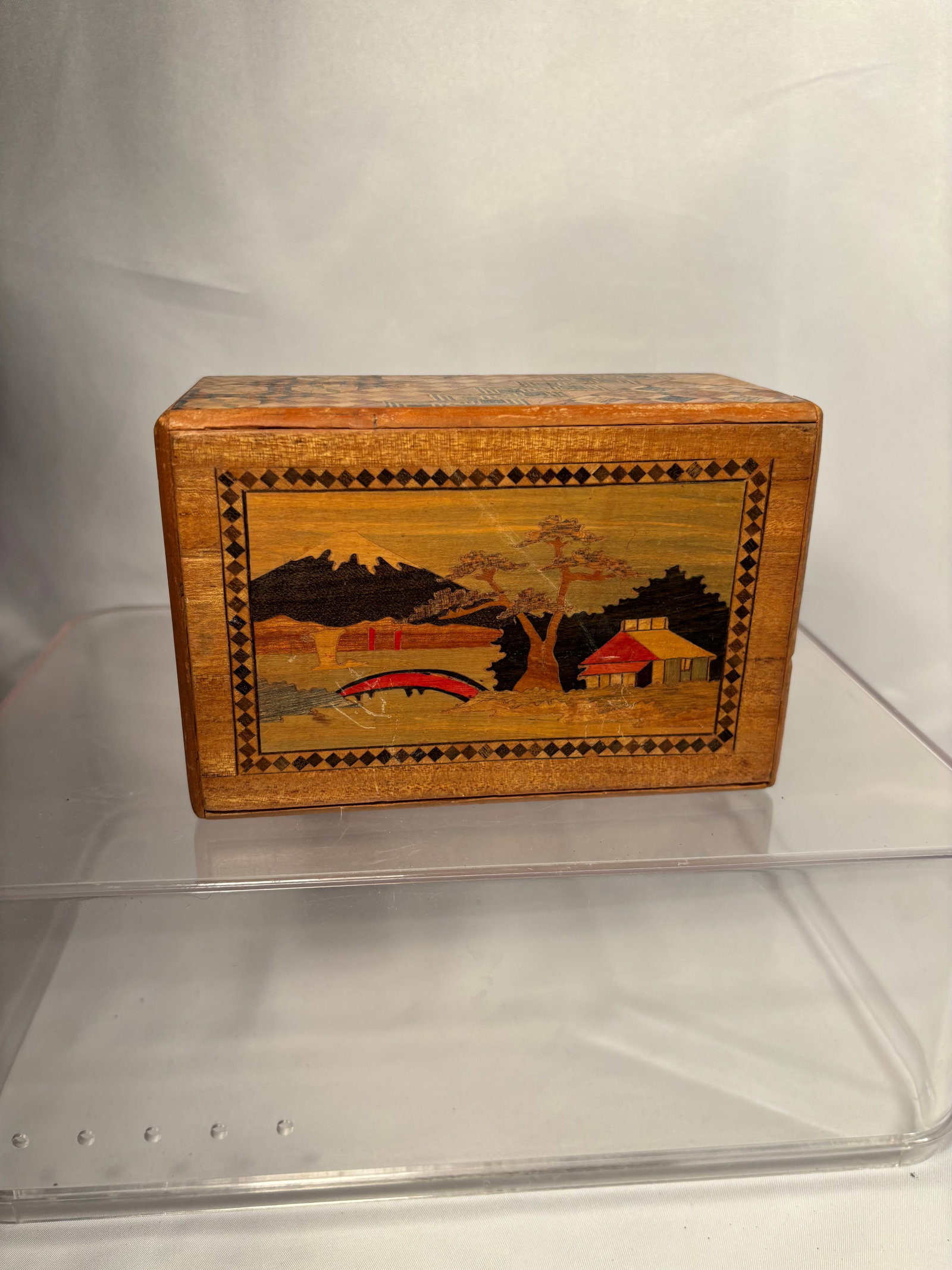 A Vintage Japanese Hakone Yosegi-Zaiku Puzzle Box with Mount Fuji and Floral Panels: A rectangular Japanese wooden secret puzzle box decorated in the traditional Hakone yosegi-zaiku technique. The top and end panels feature intricate geometric parquetry in contrasting natural wood ton
