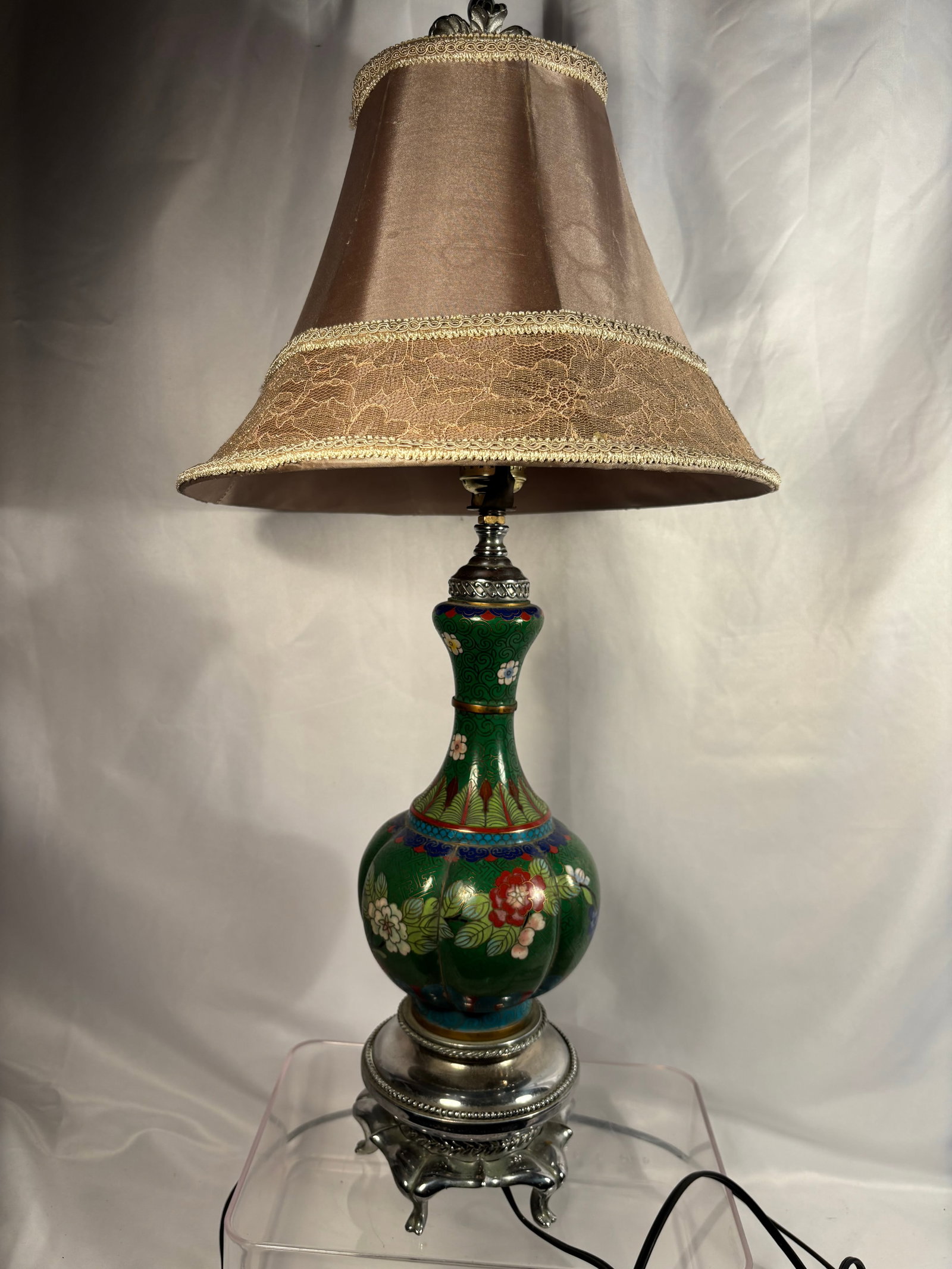 A Chinese Cloisonné Enamel Vase Mounted as a Table Lamp, Early 20th Century: A Chinese cloisonné enamel baluster vase converted into a table lamp, decorated with colorful flowering branches against a rich green ground filled with fine geometric scrollwork. The neck is bordere