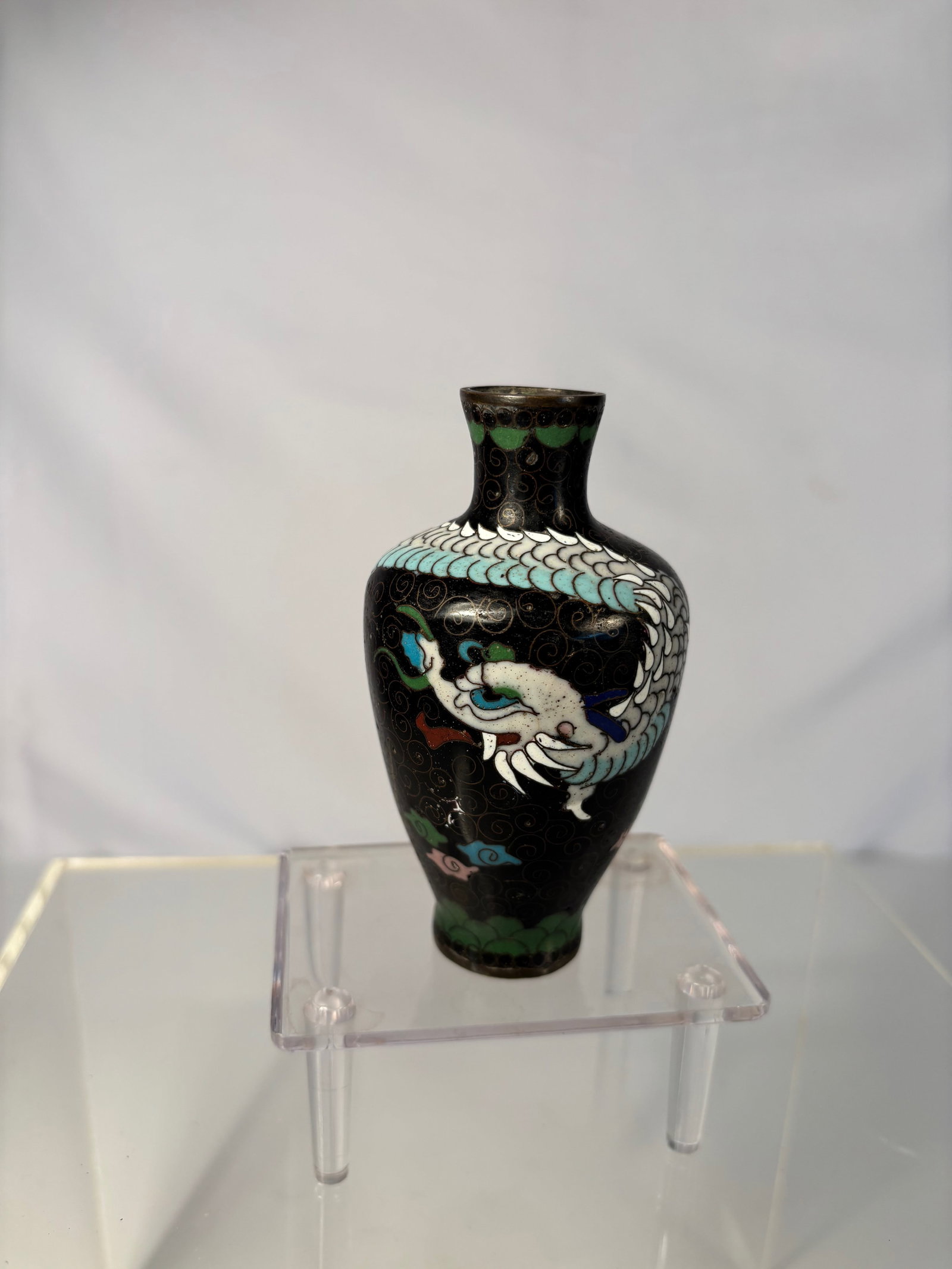 A Chinese Cloisonné Enamel Vase with Dragon: Qing dynasty(1644-1912); A Chinese cloisonné enamel vase of baluster form, decorated with a five-clawed white dragon in pursuit of a flaming pearl amidst colorful clouds on a black enamel ground,