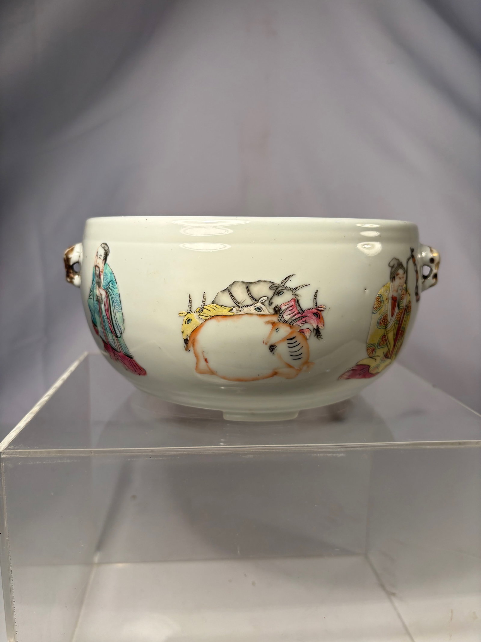 A Chinese Famille Rose Bowl with Immortal Figure and Ruyi Scepter: Qing dynasty(1644-1912) ; A Chinese famille rose porcelain bowl finely painted with an elderly immortal figure wearing a brightly patterned robe, holding a staff adorned with double-gourd charms. To t