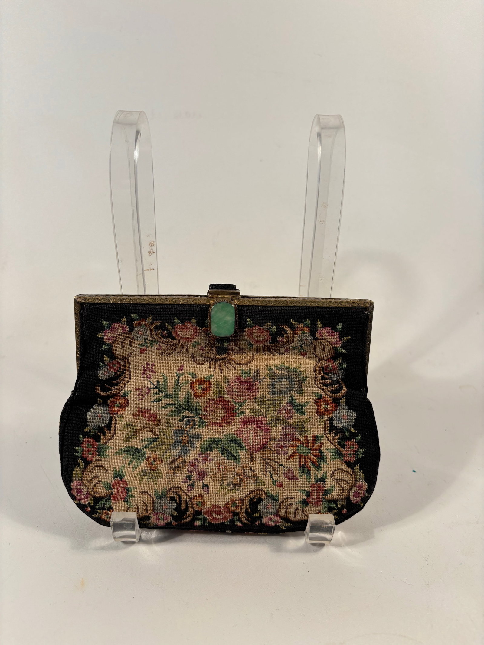 A petit point evening purse with a jadeite cabochon: early 20th century; This kind of needlepoint and frame combo was popular in European craftsmanship, especially Austrian or French, and also in Chinese export purses meant for Western markets. Dimensio