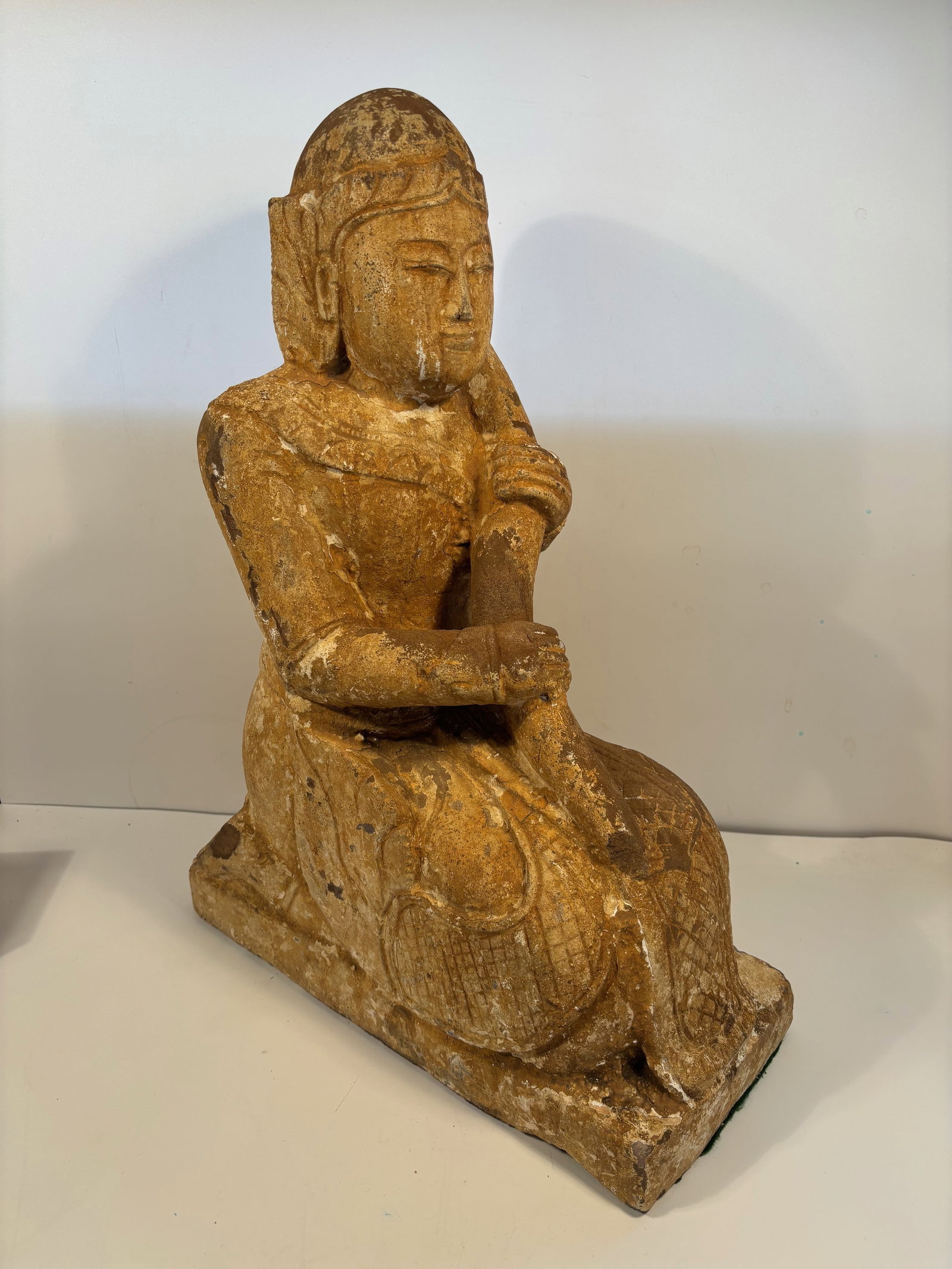 A Southeast Asian stone carved Buddha statue: Antique , at least over 100 years old. The figure is depicted in a seated position with a serene expression, characteristic of Buddhist iconography. The statue's material appears to be a light-colored