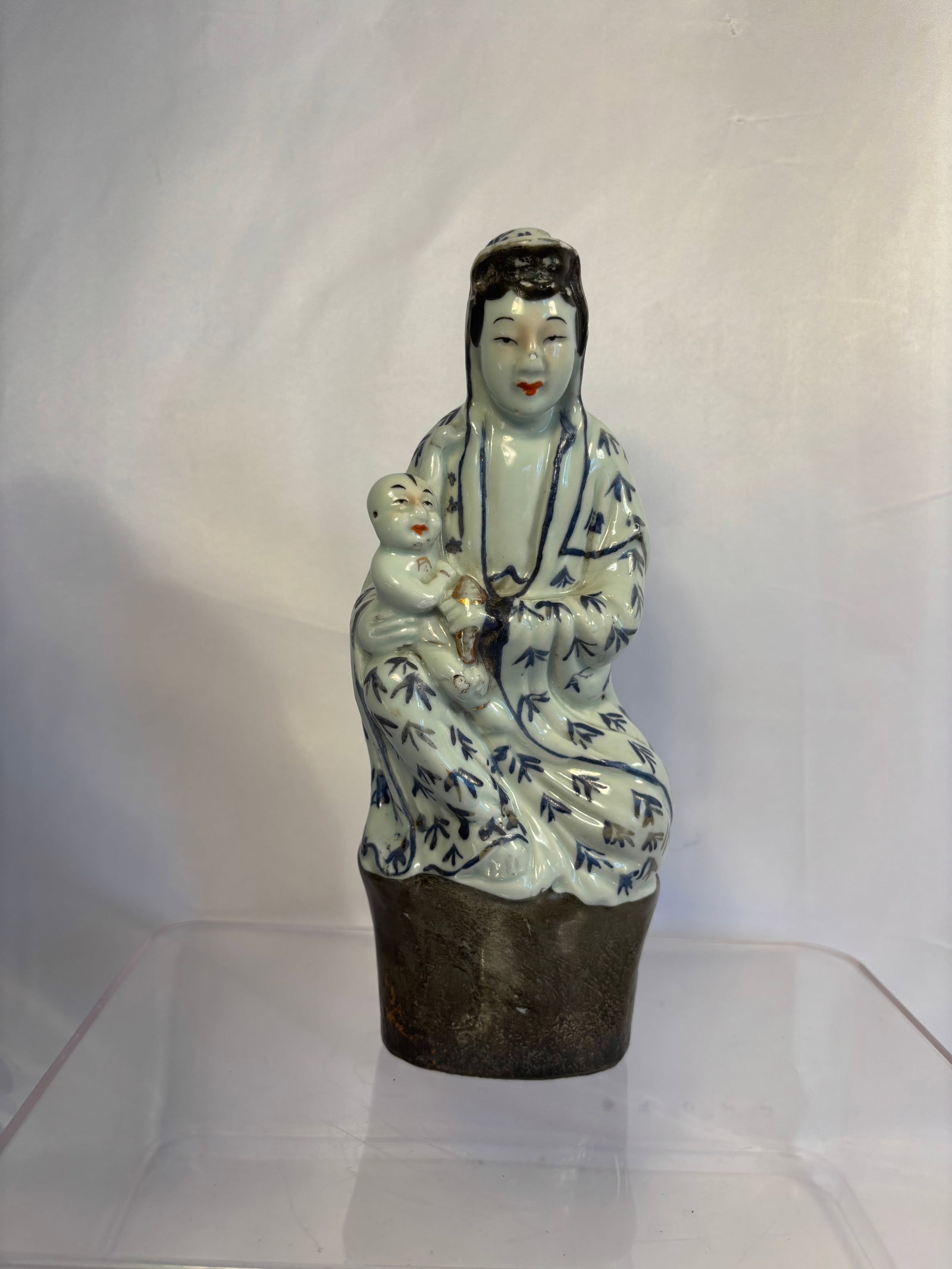 Chinese Blue and White Glazed Porcelain Songzi Guanyin with Child Figure: A Chinese porcelain figure depicting Songzi Guanyin (Child-Giving Guanyin) seated with an infant at her side. The deity is modeled in flowing robes decorated with underglaze-blue bamboo-leaf motifs, w