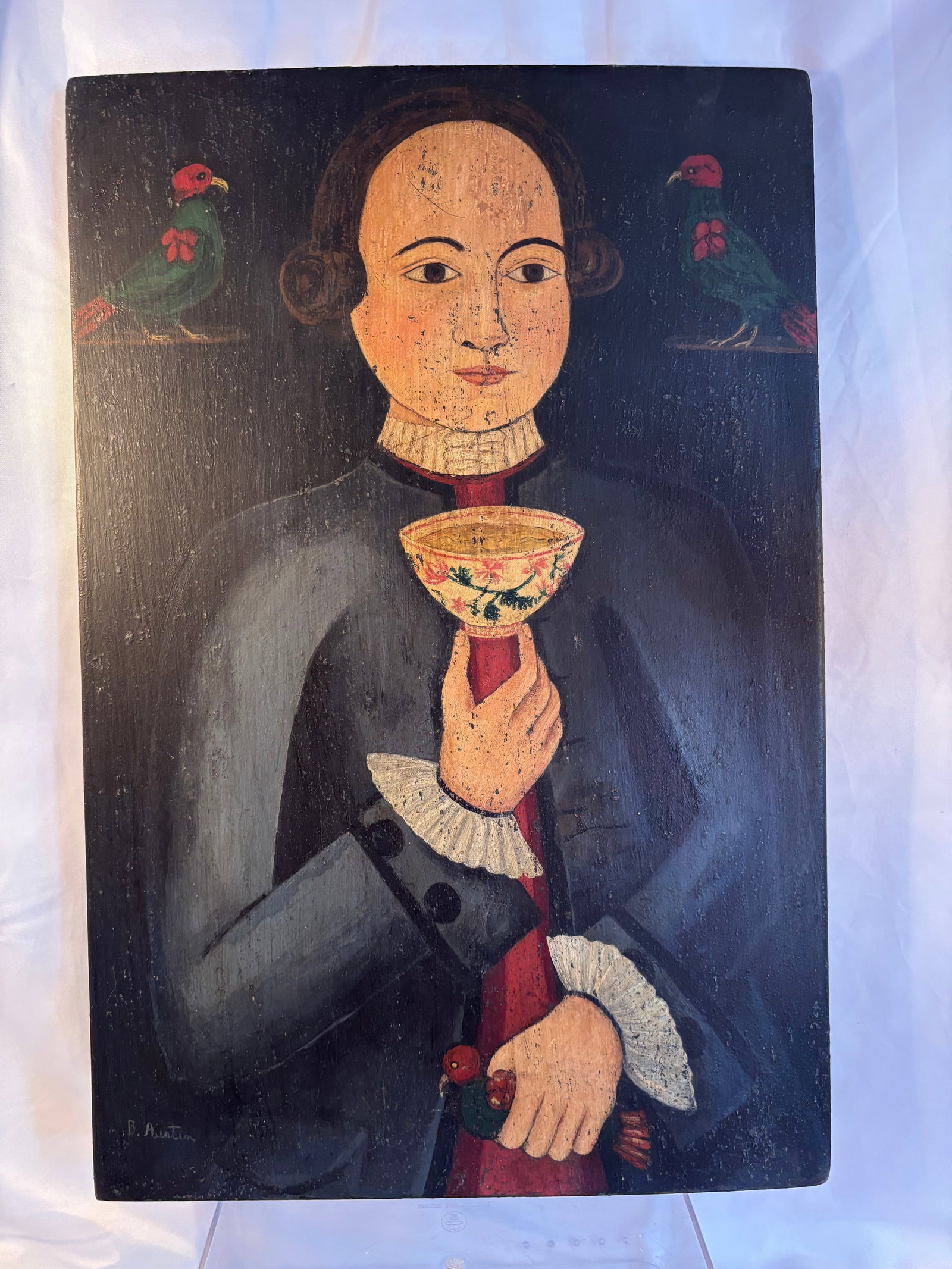 Signed B. Austin Folk Art Portrait with Parrots and Chinese Tea Bowl, Oil on Panel: A distinctive folk-art-style portrait, apparently painted in oil or acrylic on a wooden panel. The composition depicts a formally dressed figure wearing a dark coat with a white ruffled collar and cuf