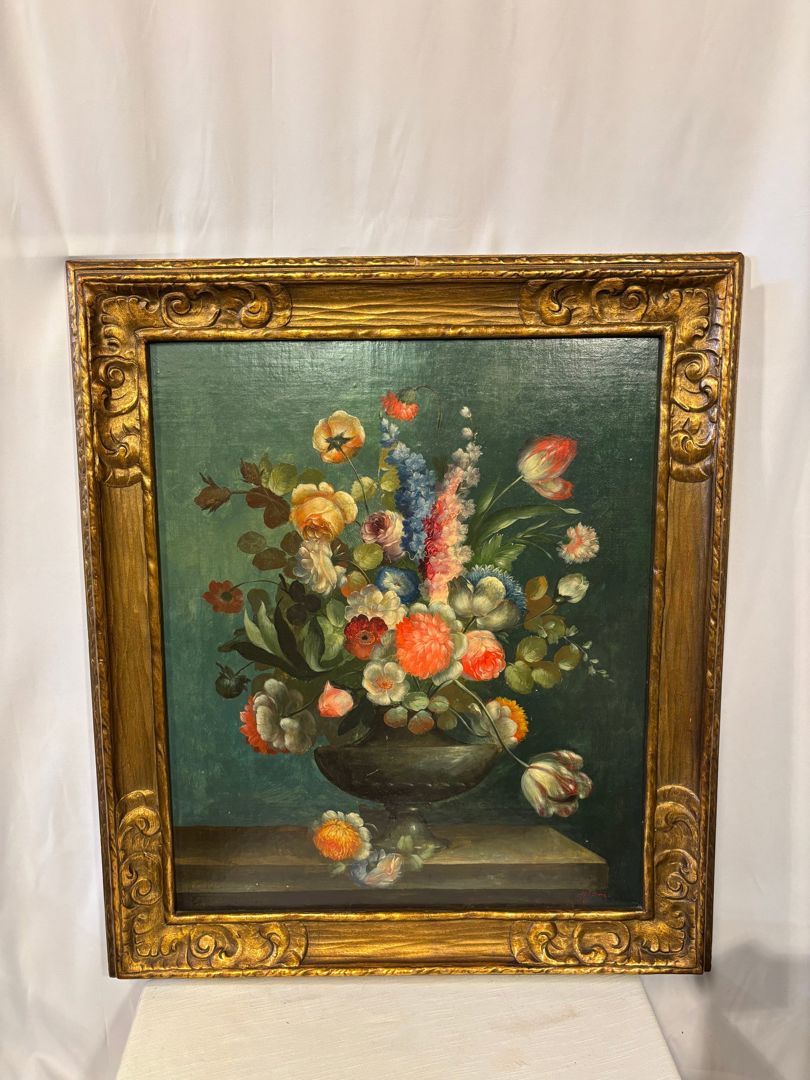 De Dong Signed Floral Still Life Oil on Canvas: A decorative oil-on-canvas still life by De Dong, depicting a lush arrangement of colorful flowers in a classical urn against a deep green background. Signed “De Dong” at the lower right and p