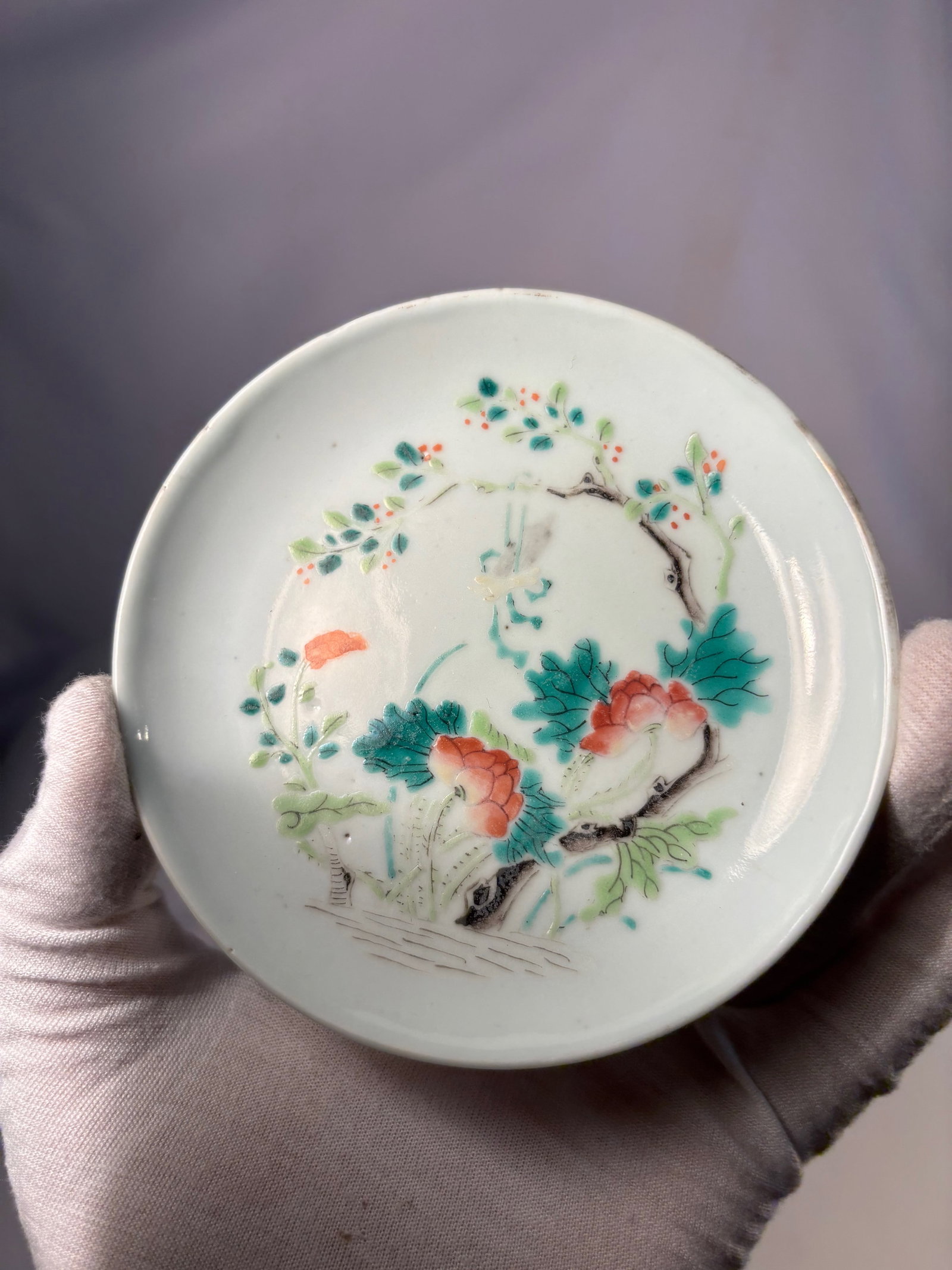 A Chinese famille rose hand painted Porcelain plate with TongZhi Mark: A Chinese famille rose hand-painted porcelain plate, decorated to the interior with floral and branch motifs in delicate polychrome enamels. The shallow rounded form is supported on a short foot,