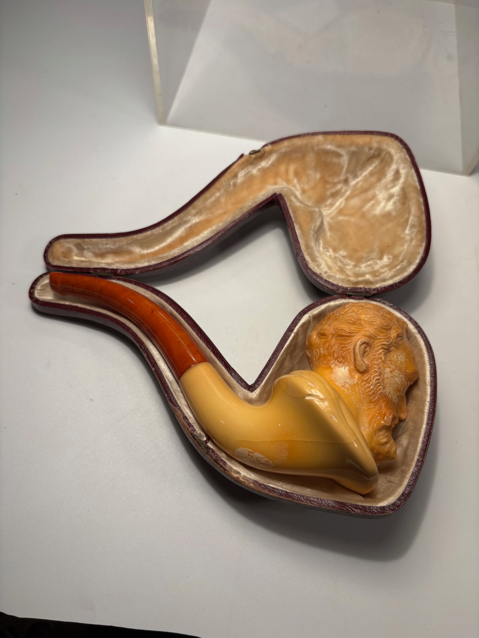 A European butterscotch Amber & Meerschaum Figural Tobacco Pipe with Fitted Case, Signed and Marked: A European figural tobacco pipe featuring a butterscotch amber mouthpiece and a finely carved meerschaum bowl in the form of a bearded gentleman’s head. The amber stem displays a rich butterscotch t