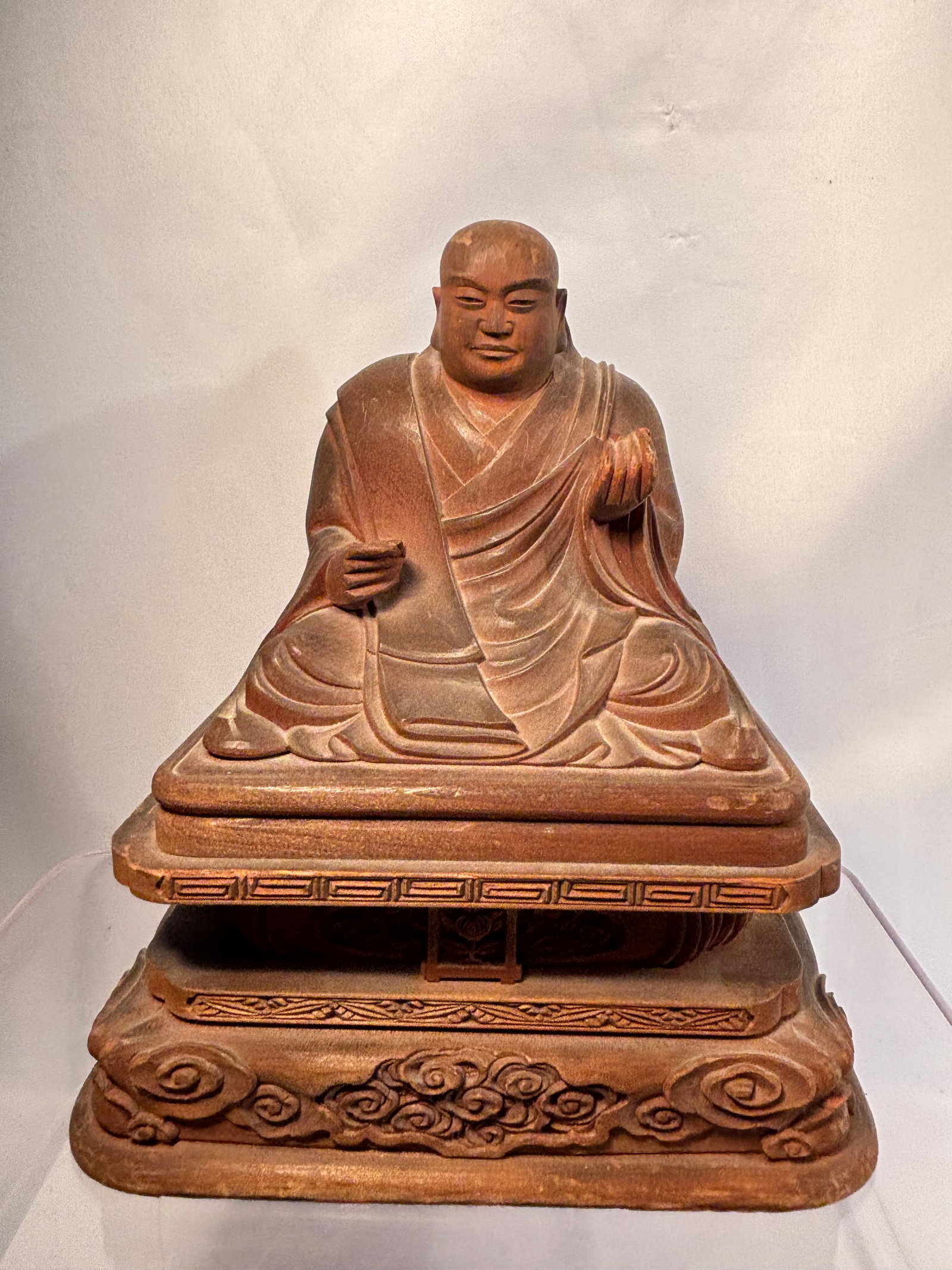 Antique Japanese Carved Wood Figure of K?b? Daishi (K?kai), Circa 1850: A Japanese carved wood figure depicting K?b? Daishi (K?kai), founder of Shingon Buddhism, seated in layered monastic robes upon an elaborately carved tiered pedestal decorated with stylized cloud and 